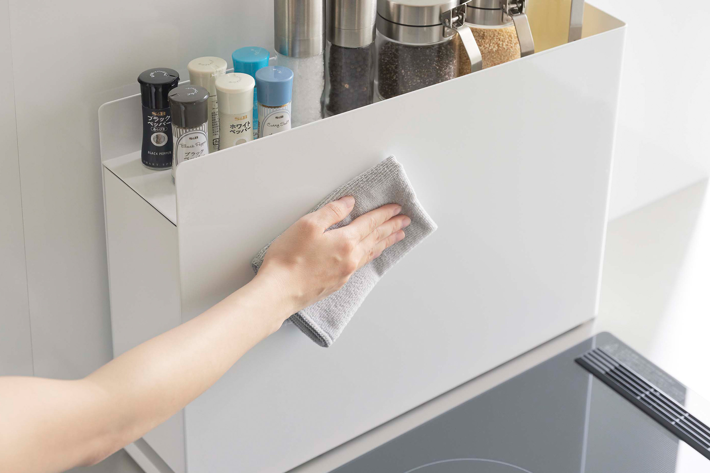 Close up of cleaning a white Yamazaki Home Sliding Seasoning Rack