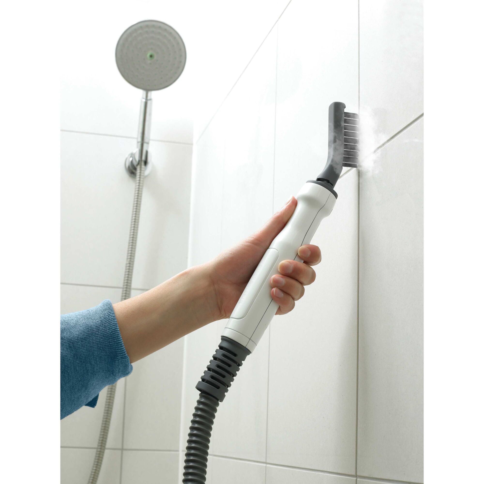 8 in 1 complete steam cleaning system being used by a person to clean bathroom tiles.