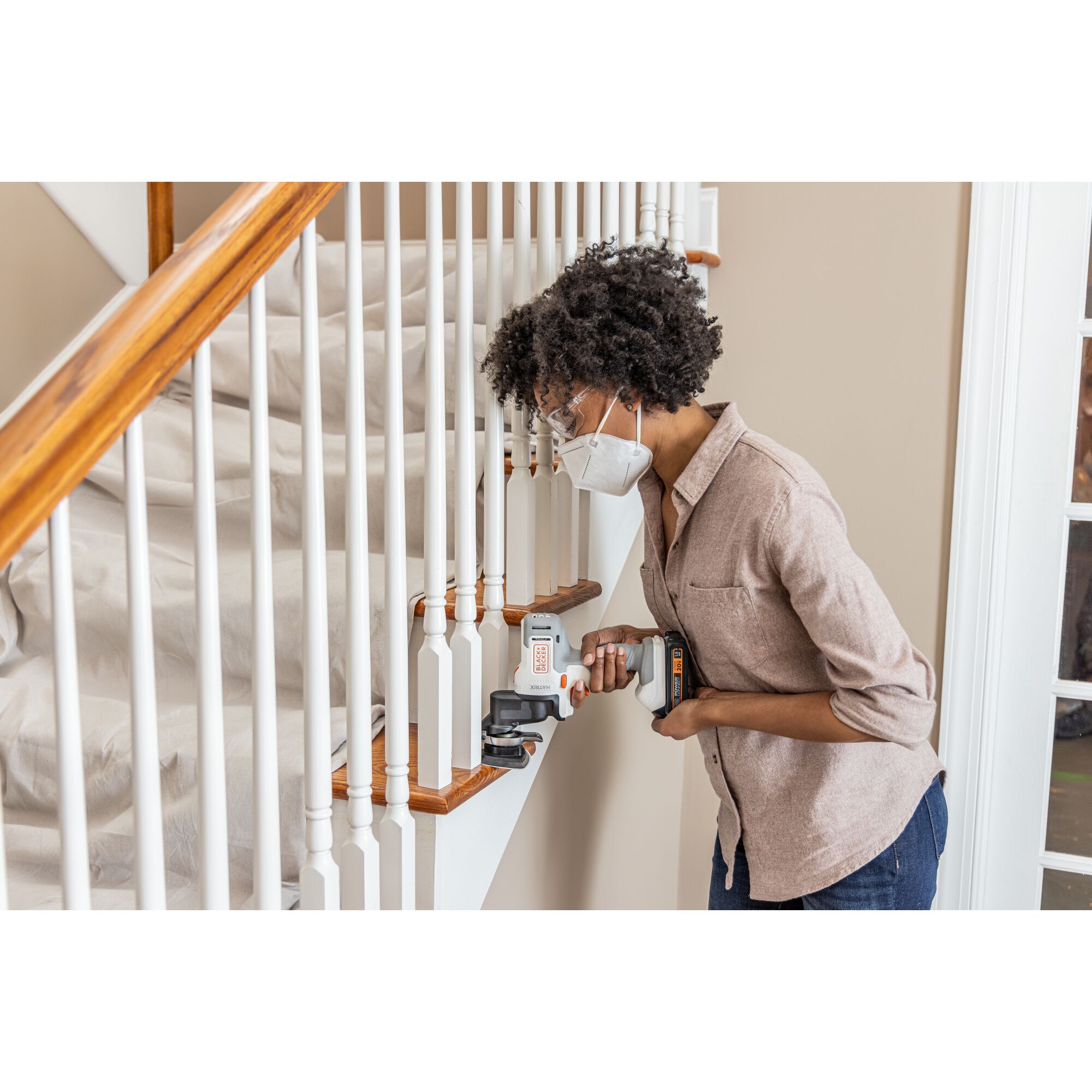 Person sands in between spindles on a staircase with the BLACK+DECKER MATRIX multi-tool attachment