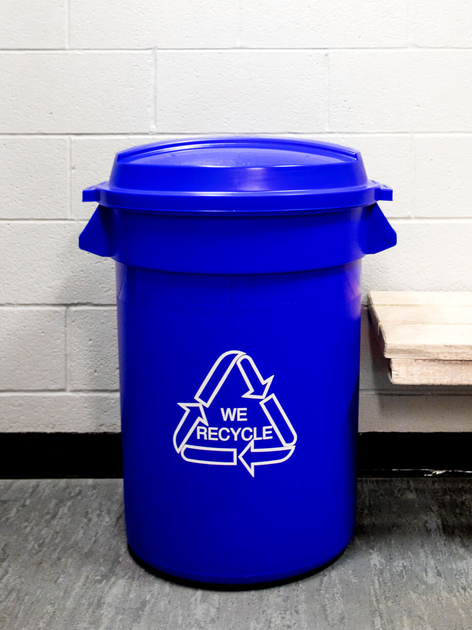 large plastic recycling bin with printed body graphics and blue lid in a hockey dressing room