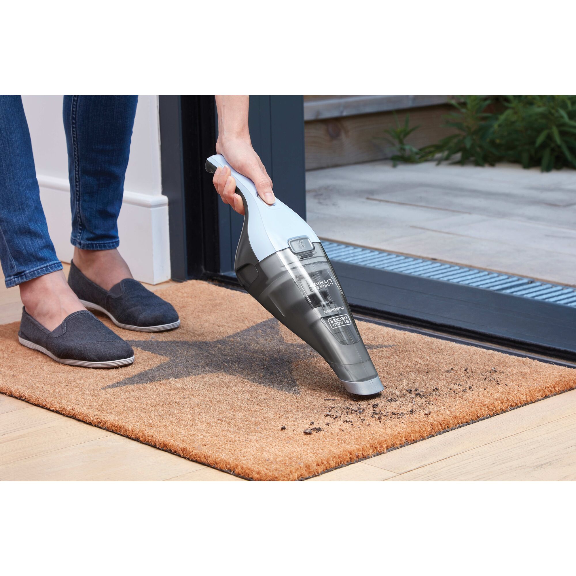 Dustbuster quickclean hand vacuum being used to vacuum dirt from a doormat.