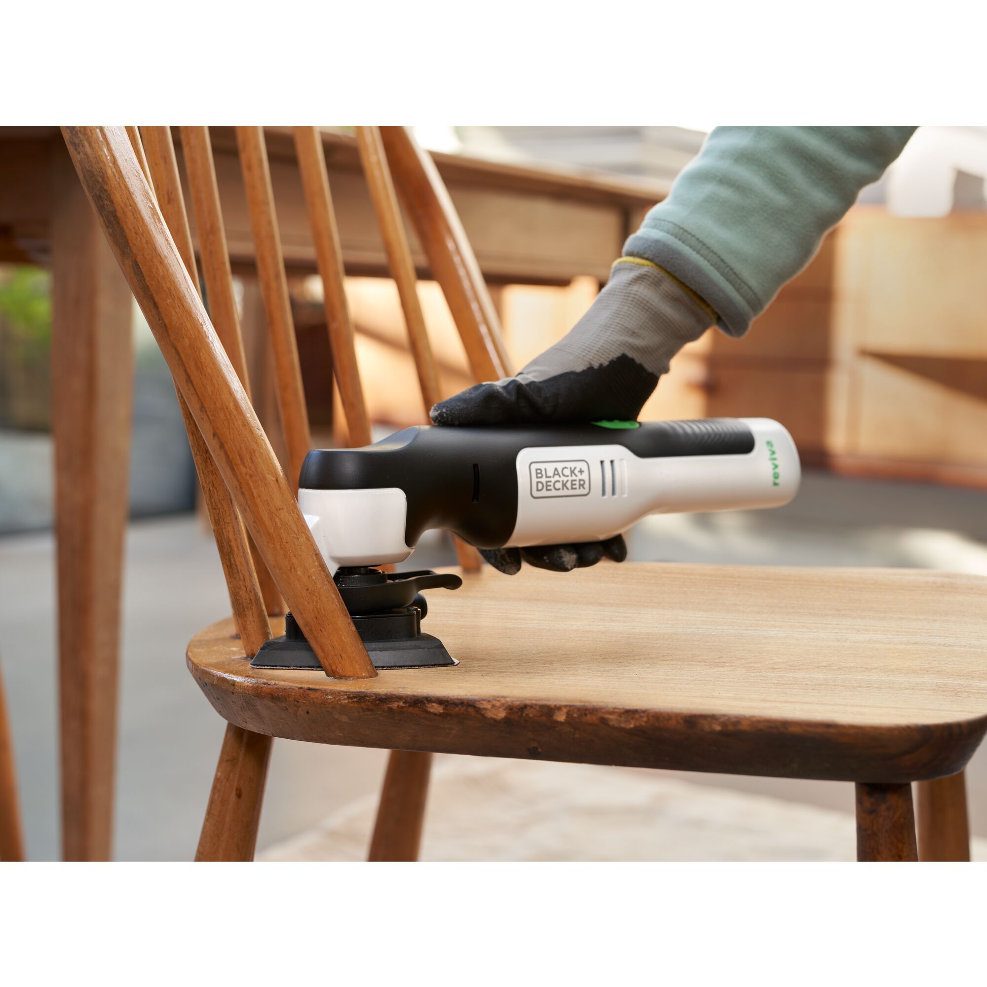 reviva 12V MAX* Oscillating Multi-Tool sanding in between spindles on a chair.