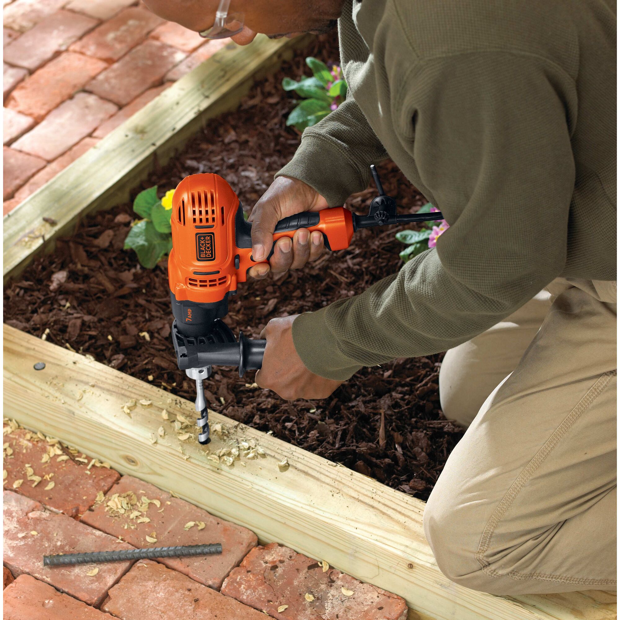 Man using BLACK+DECKER electric drill to build outdoor decking