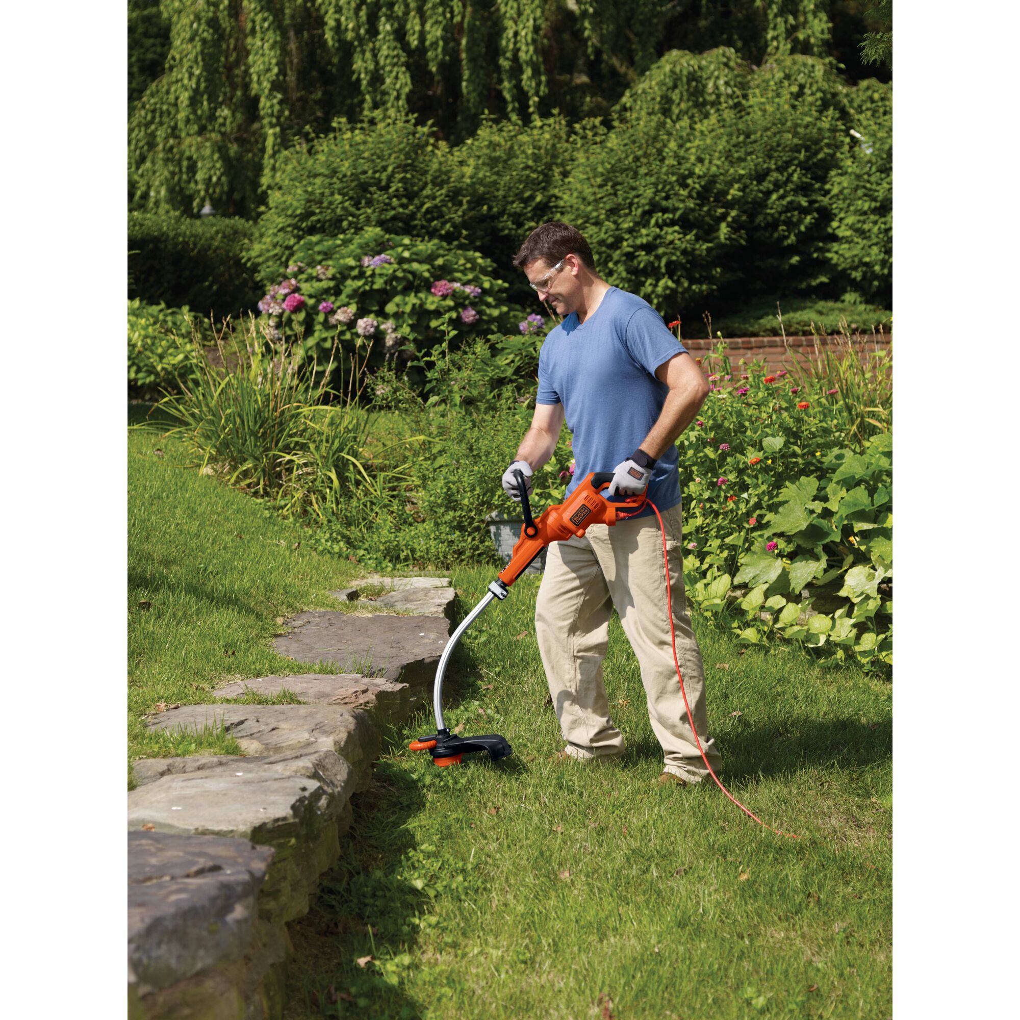7.5 amp 14 inch Trimmer / Edger being used by a person to trim grass.