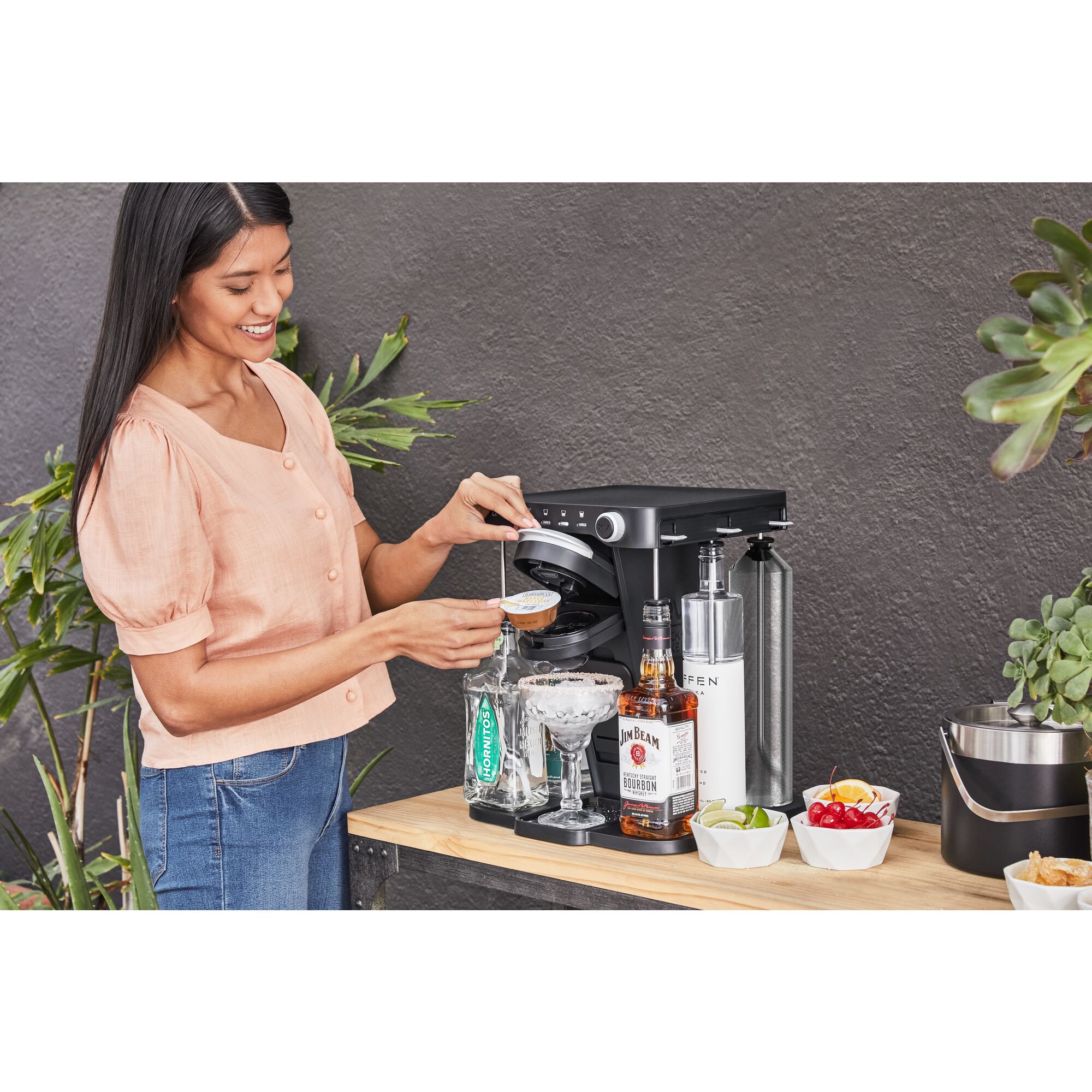 woman, on the patio, inserting a margarita drink capsule into the bev by BLACK+DECKER\u2122 cocktail maker
