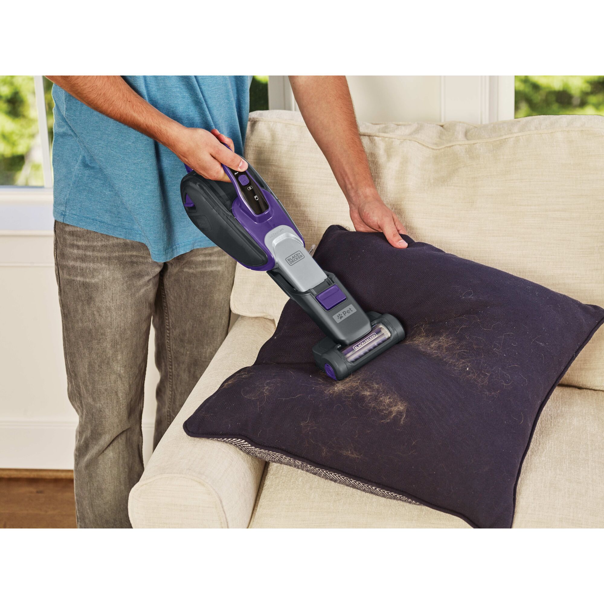 Dust buster Hand Vacuum Pet being used to clean pet hair from cushion.