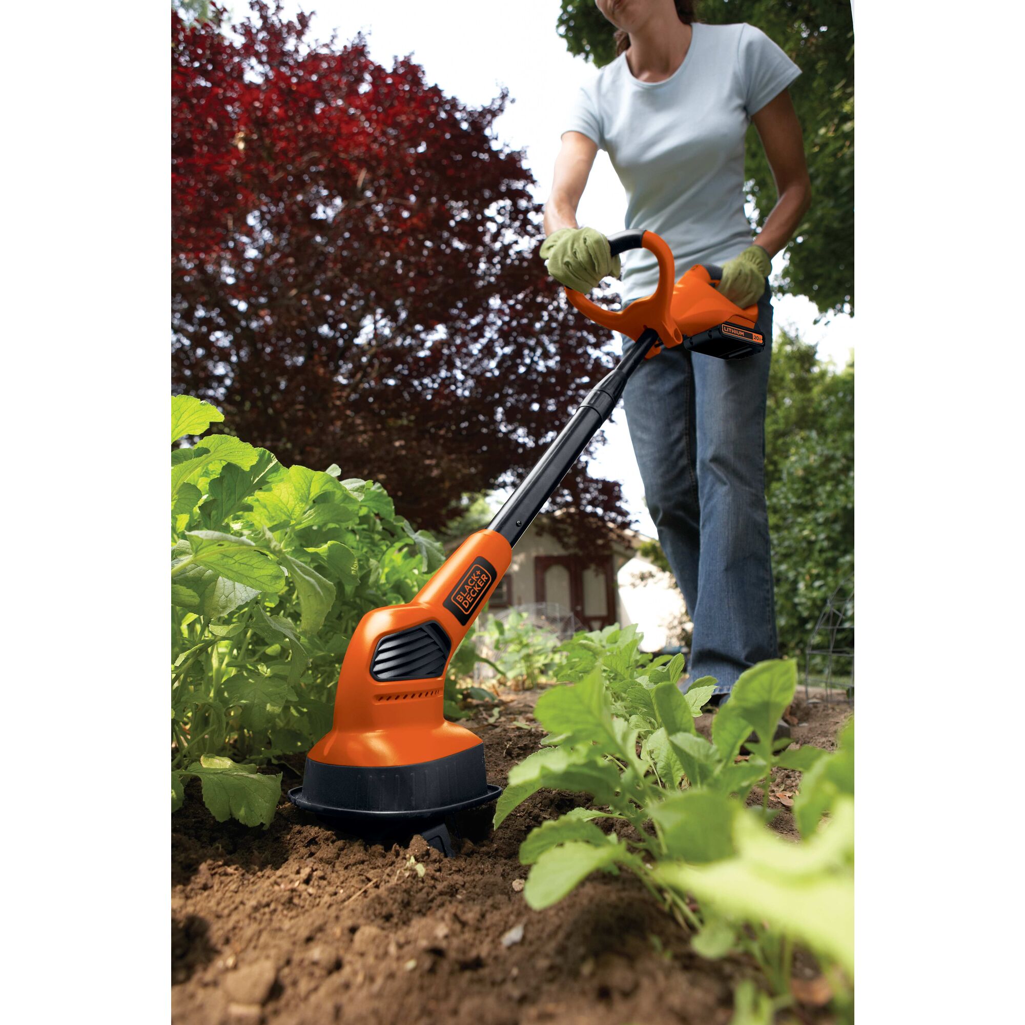 20 volt MAX Lithium garden cultivator being used by a person to cultivate land.