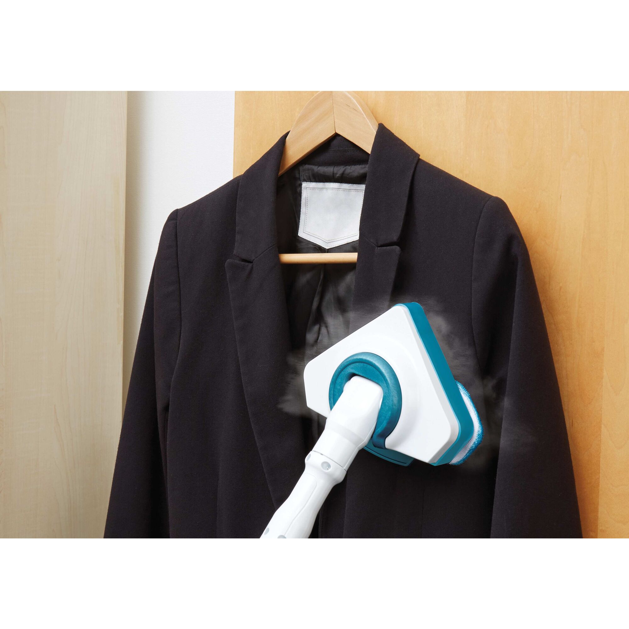 Garment steamer attachment for the steam mop used on a black blazer