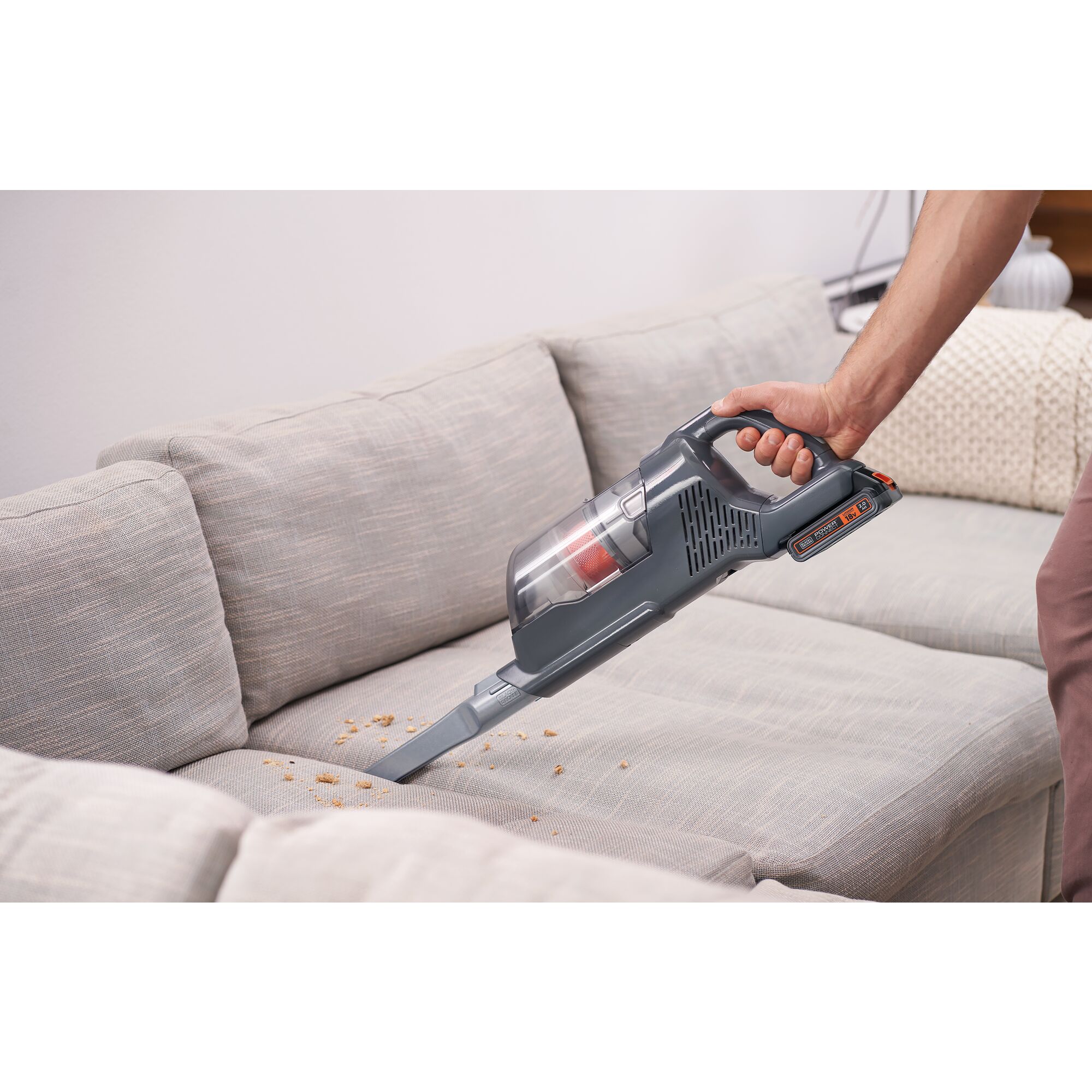 POWER SERIES plus Cordless Stick Vacuum being used for cleaning mess on sofa.