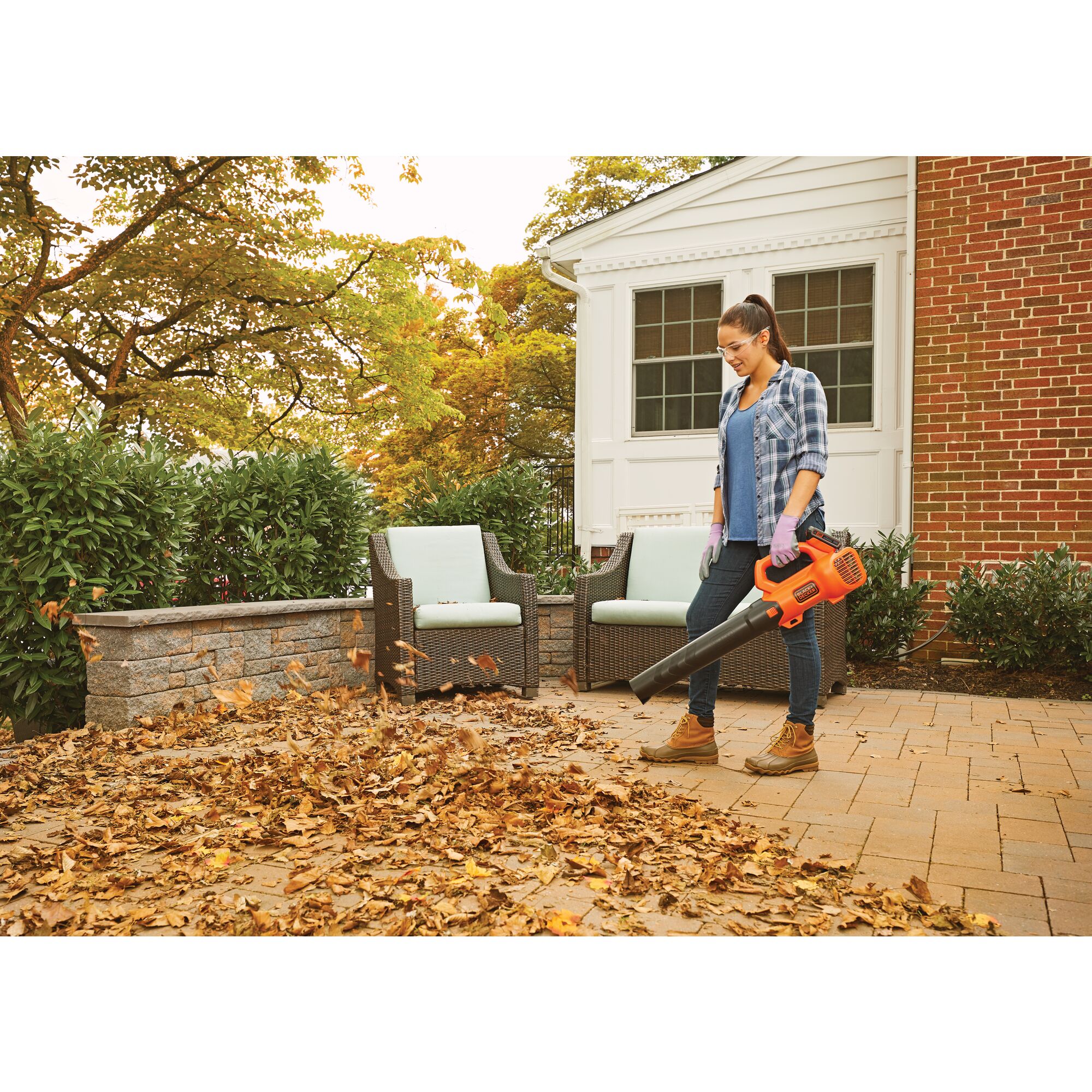 Axial Leaf Blower being used by person for backyard cleanup of rusty leaves.