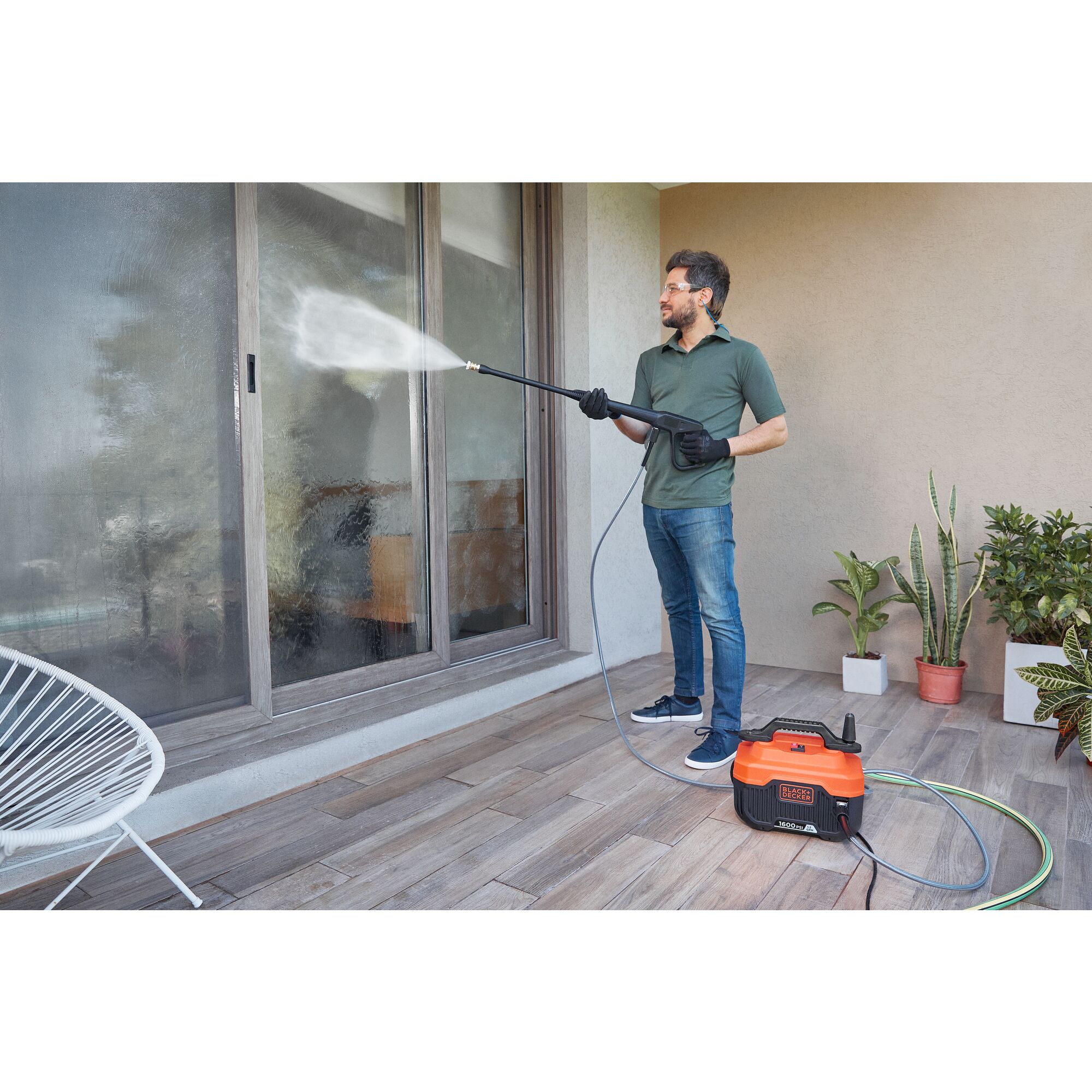 Person using Black and decker 1600-Psi 1.2-Gpm Pressure Washer to clean glass doors