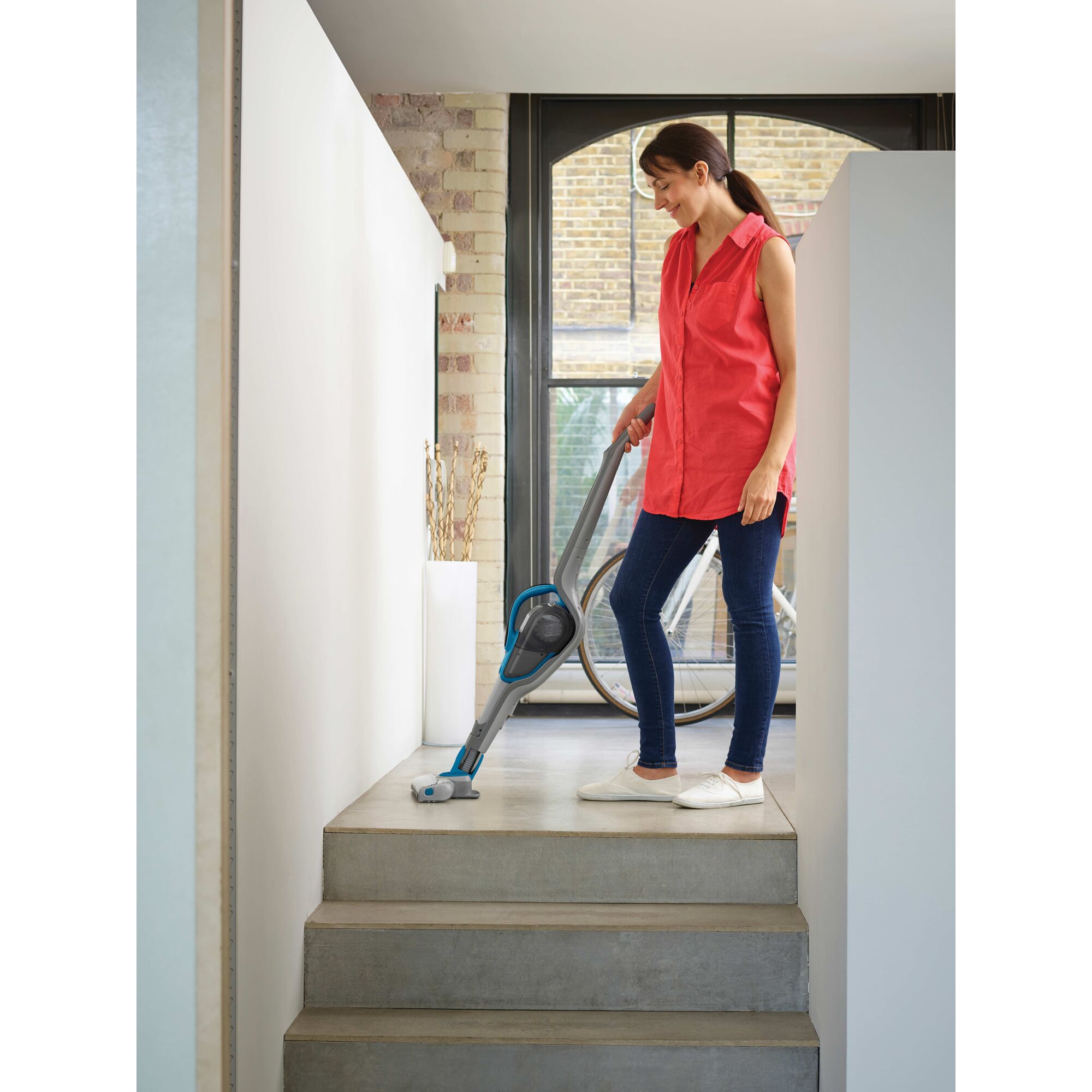 Cordless Lithium 2 in 1 Stick Vacuum being used for cleaning floor by person.