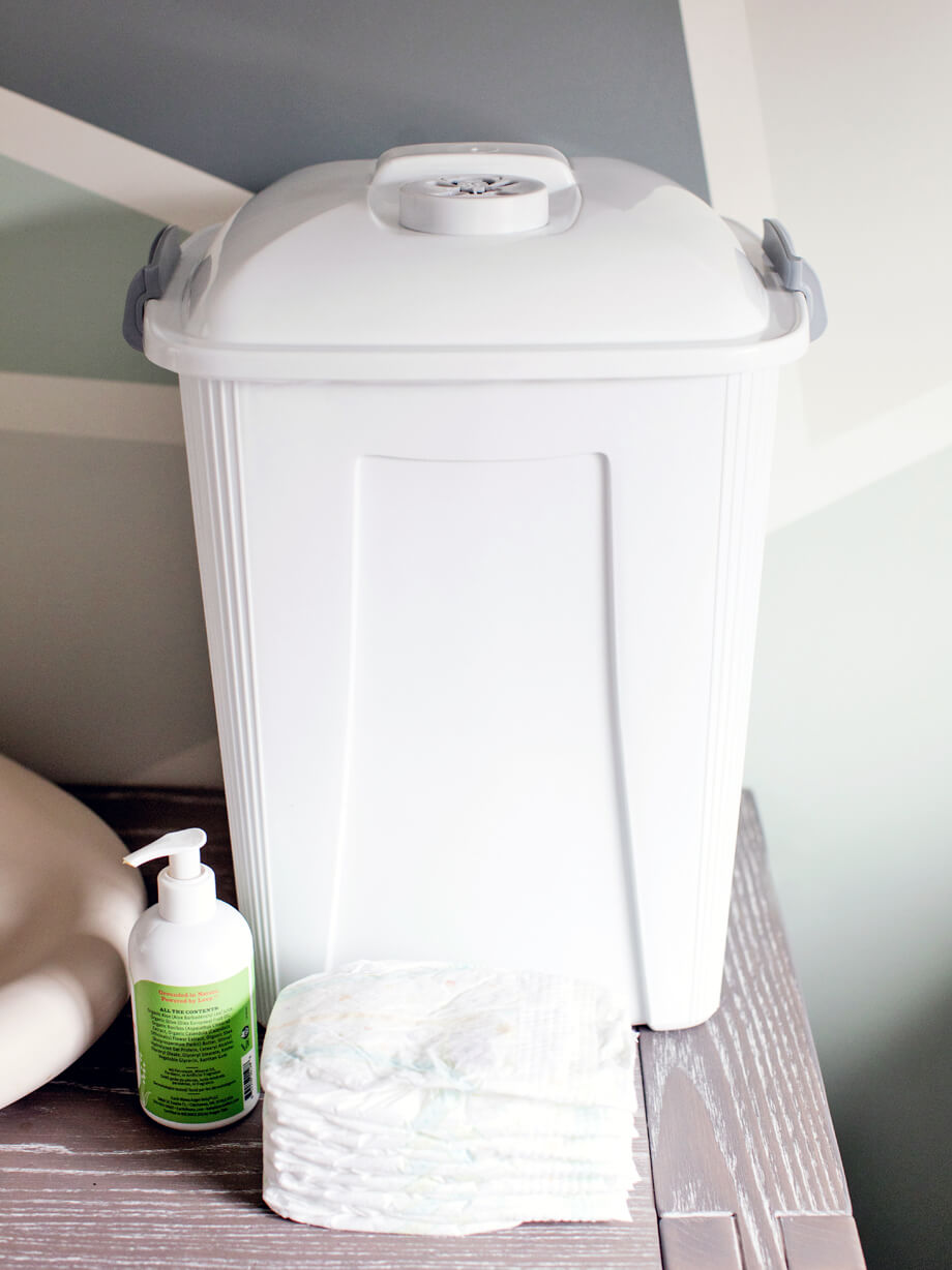 durable white plastic diaper container for collecting used diapers sitting on a changing table in a baby's room