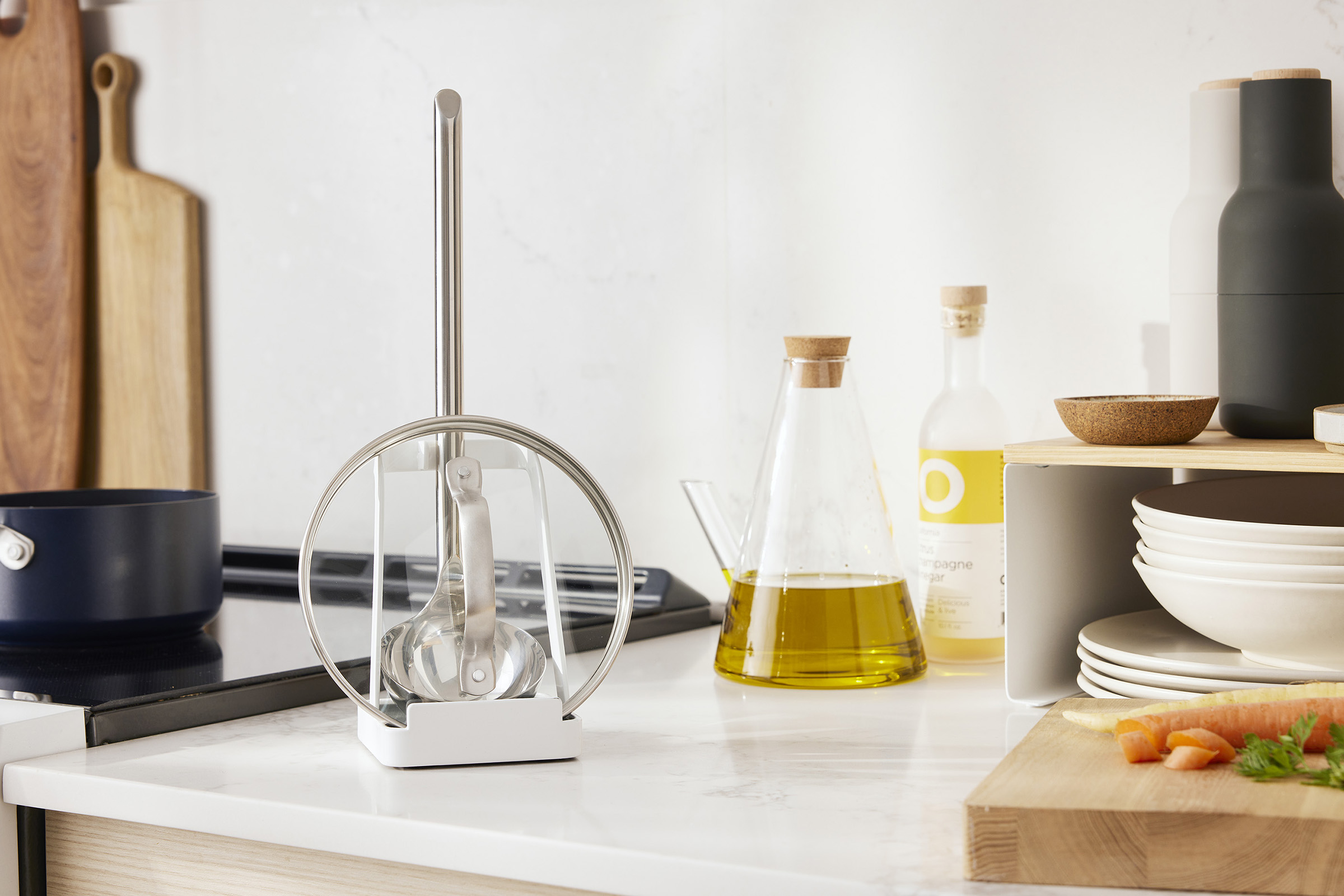 White Lid and Ladle Stand on a kitchen counter next to an oven