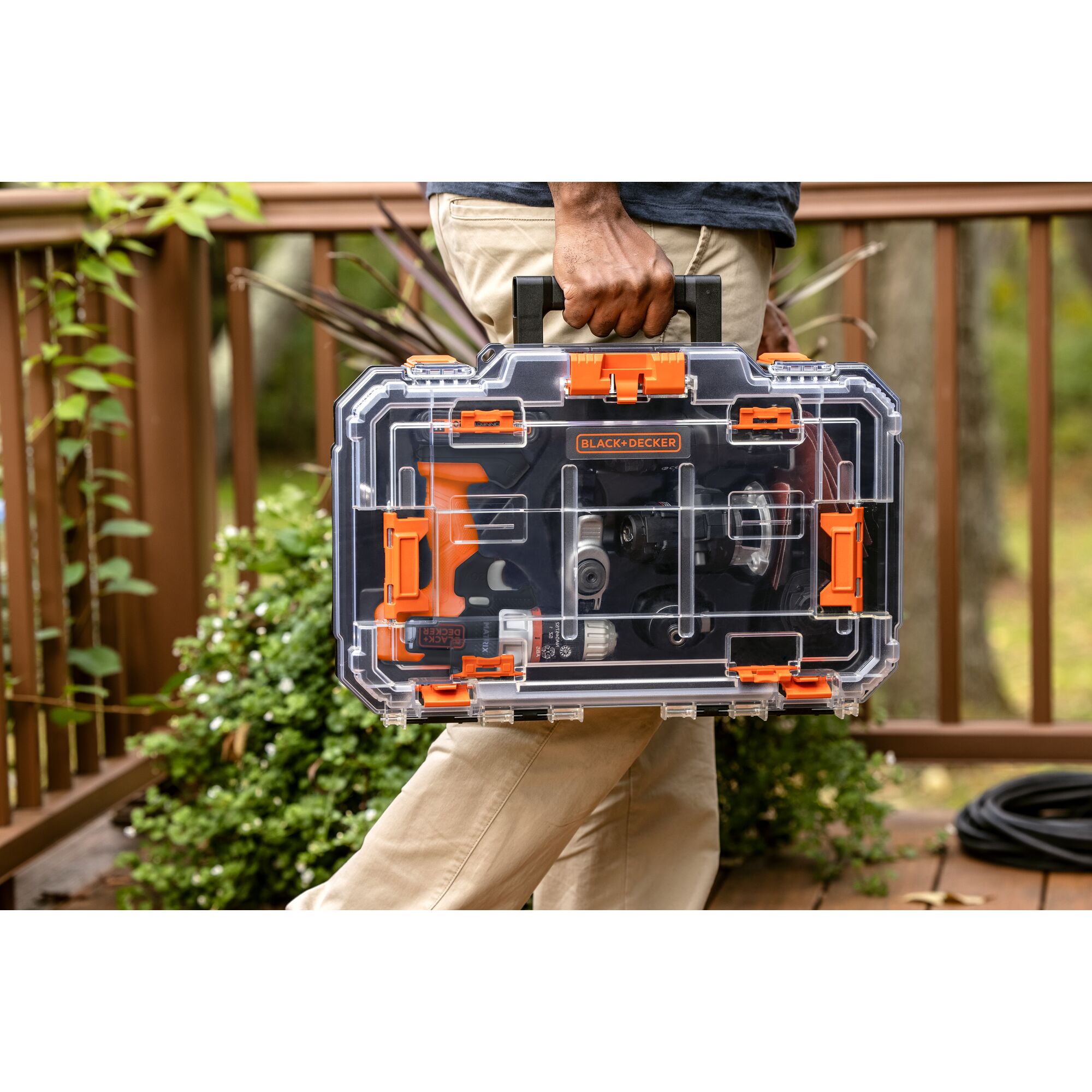 Person carrying black and decker 6 tool Cordless Drill Combo Kit with Case.