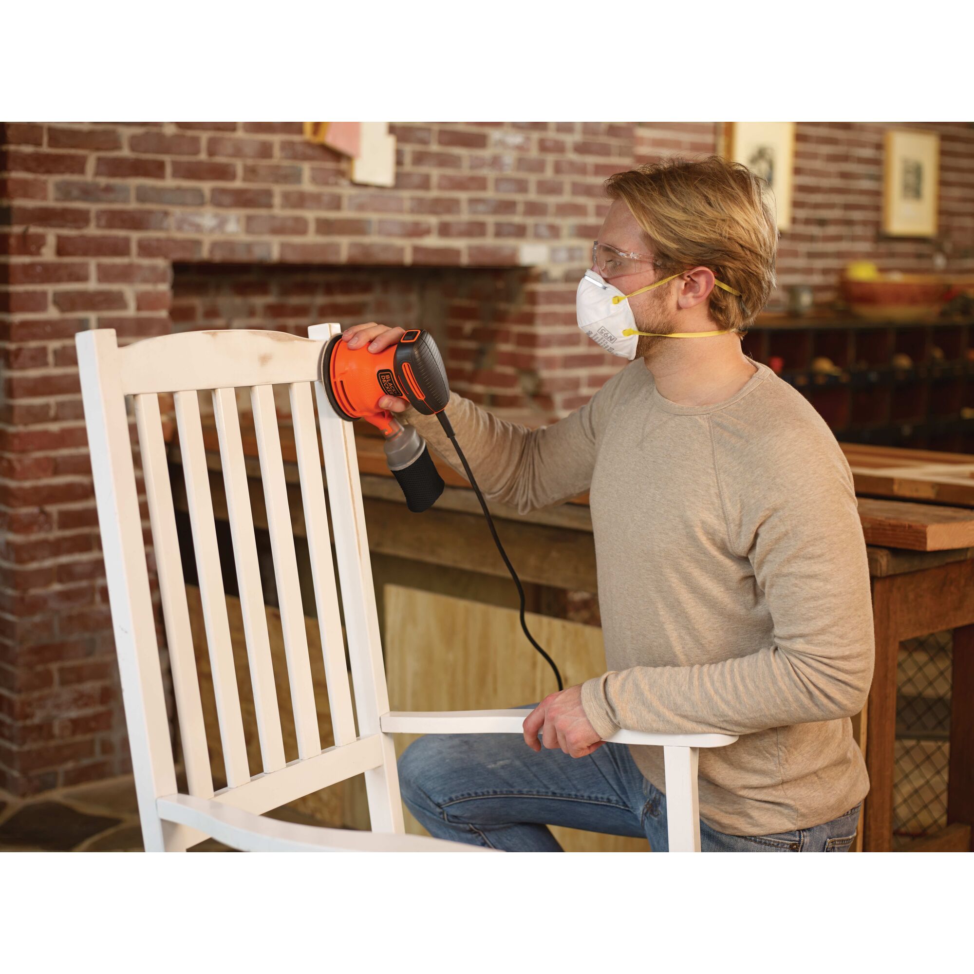 5 inch Random Orbital Sander being used to sand white finish off of a wooden rocking chair