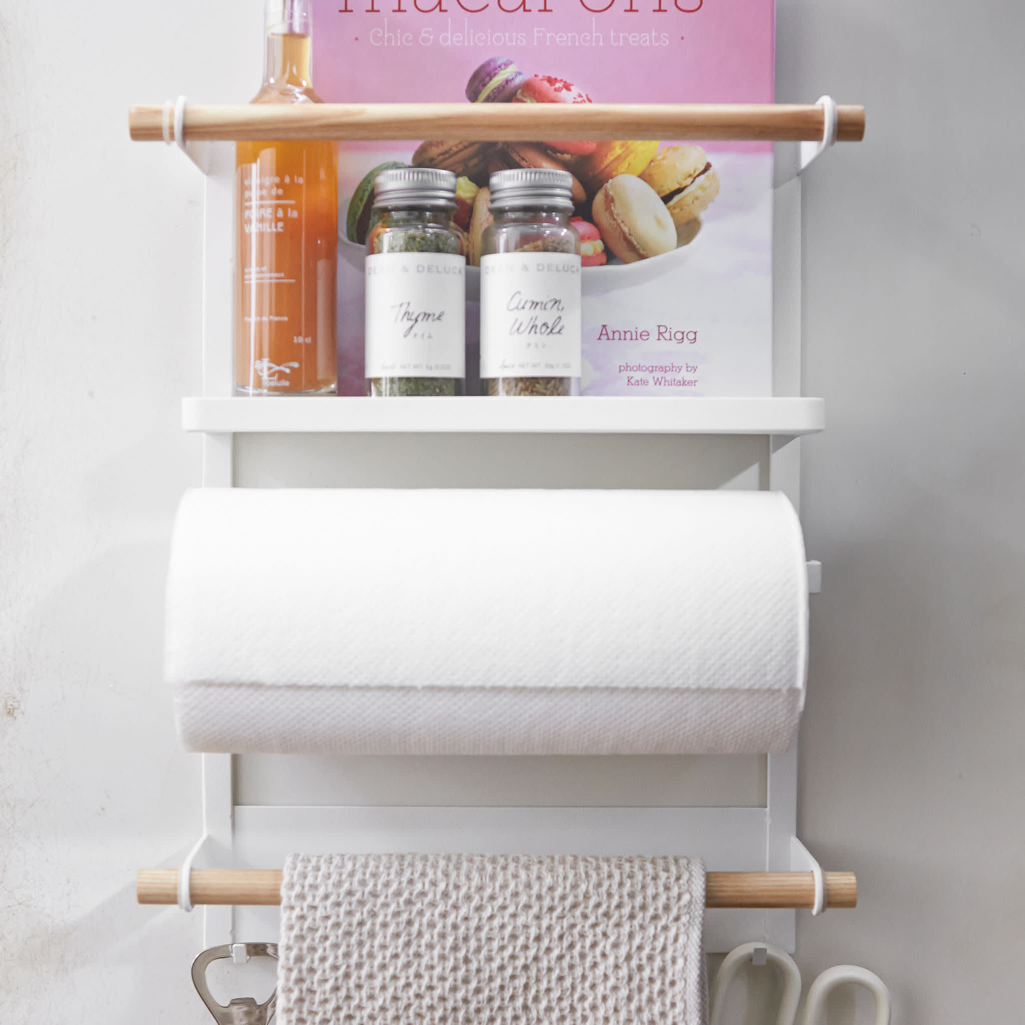 Entfernen Sie mit der Hand das Papierhandtuch von der magnetischen Küchenablage am Kühlschrank.