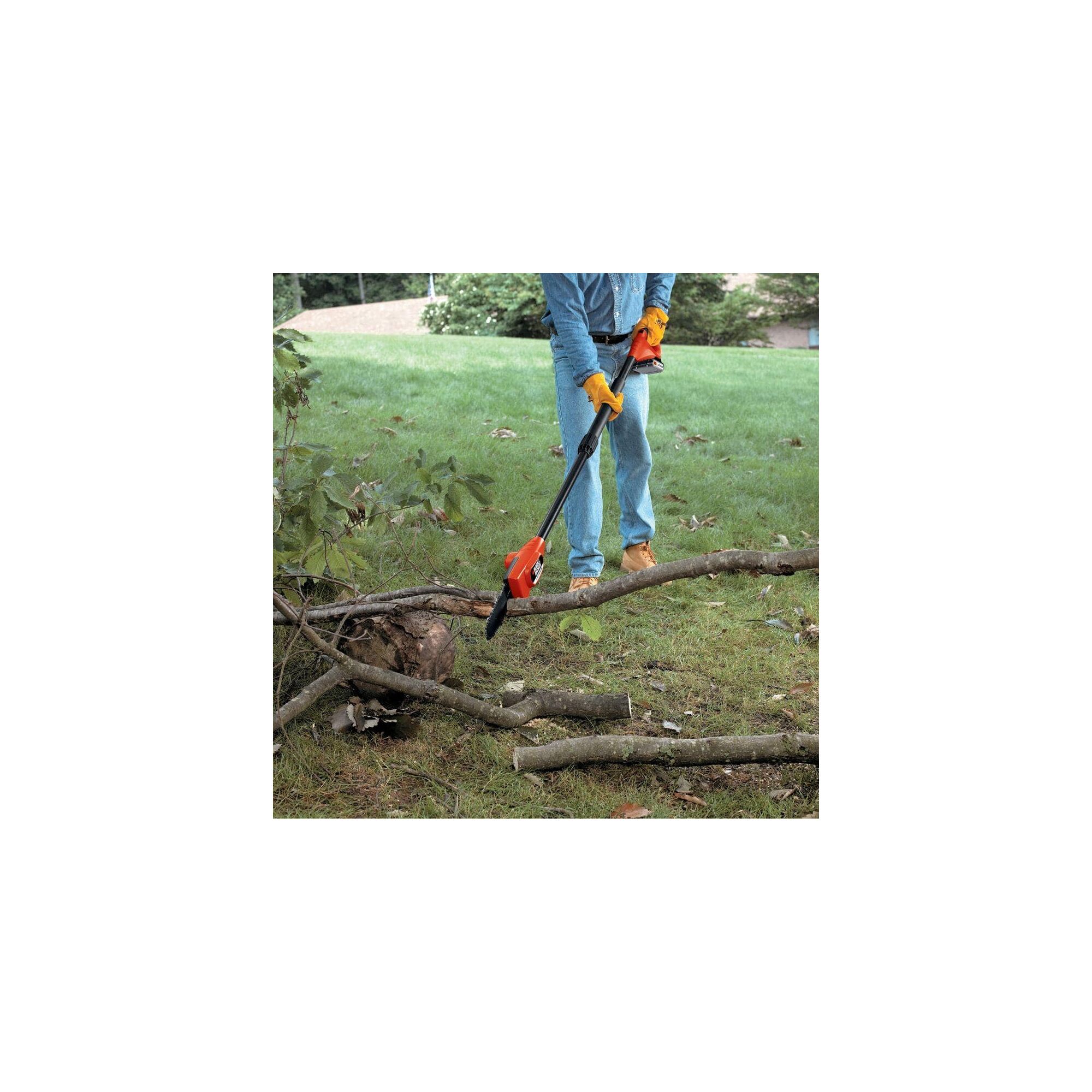Man using Lithium Pole Pruning Saw to cut fallen branches.