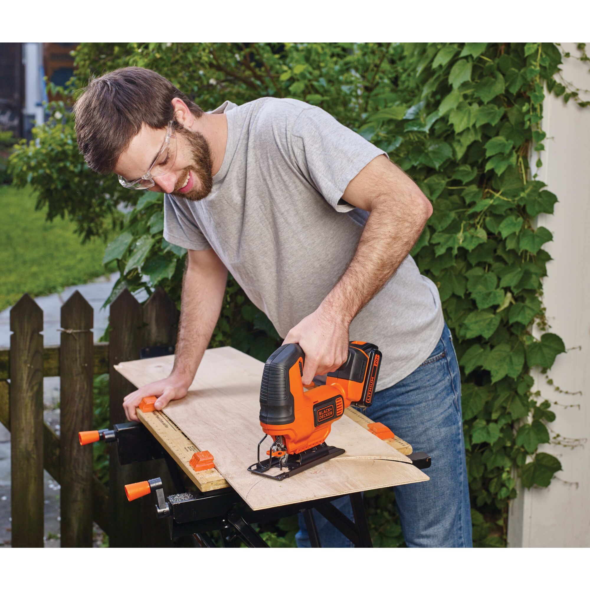20 volt MAX cordless jigsaw being used by a person to cut wood outdoors.