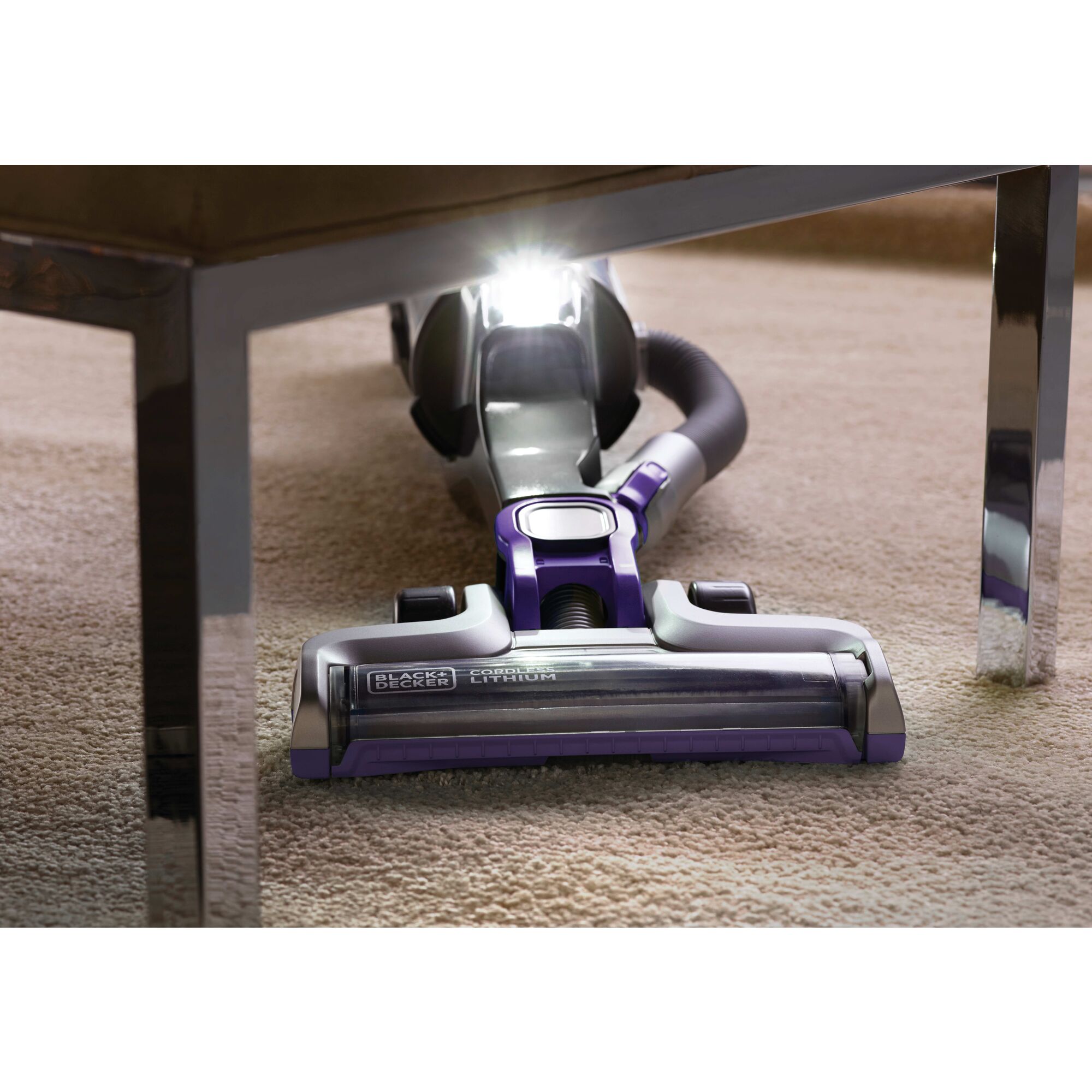 POWER SERIES PRO Cordless 2 in 1 Pet Vacuum being used for cleaning carpet under table with L E D turned on.