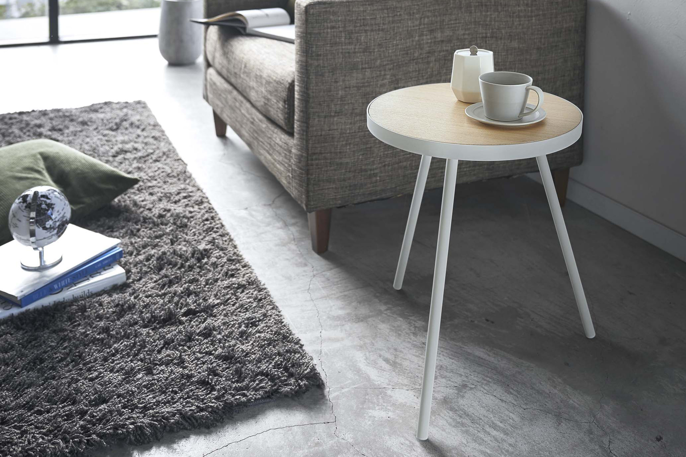 White Side Table by Yamazaki Home in a living room holding a cup of coffee and a sugar canister.