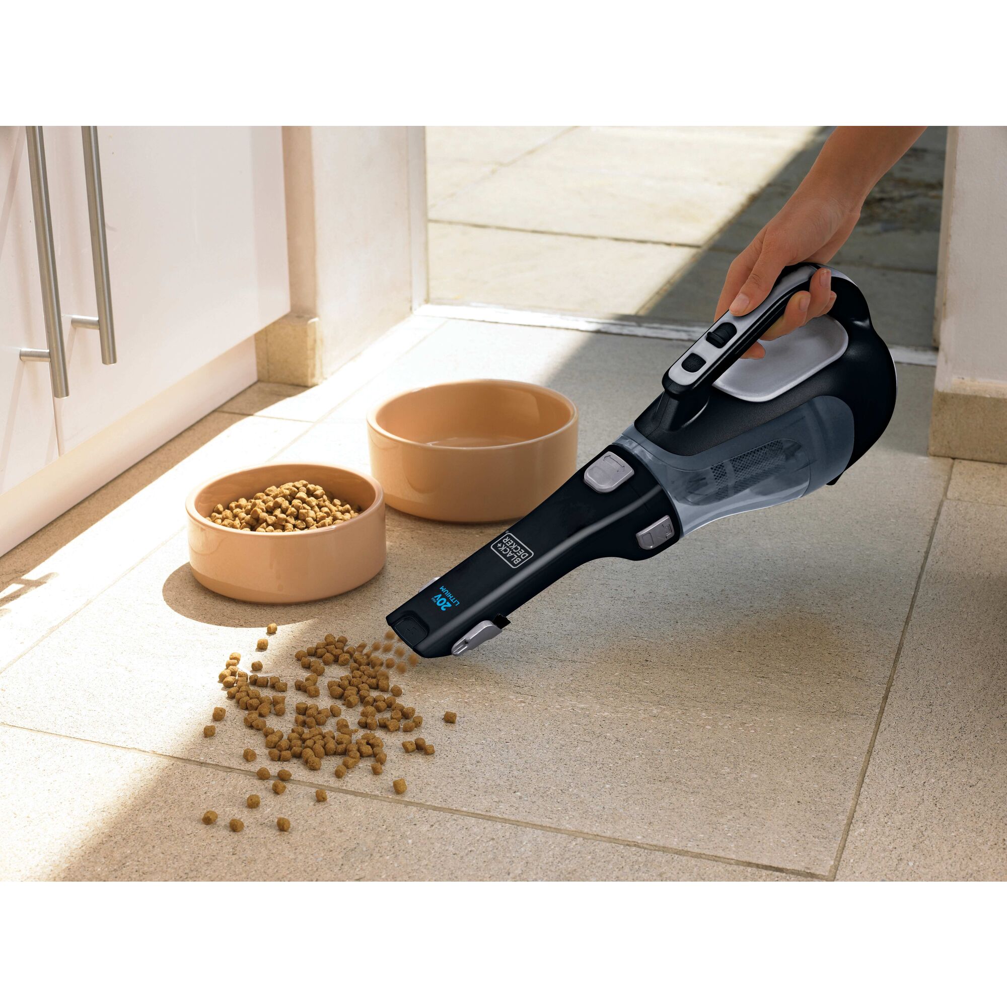 Dustbuster Cordless Hand Vacuum being used to clean pet food on a floor.