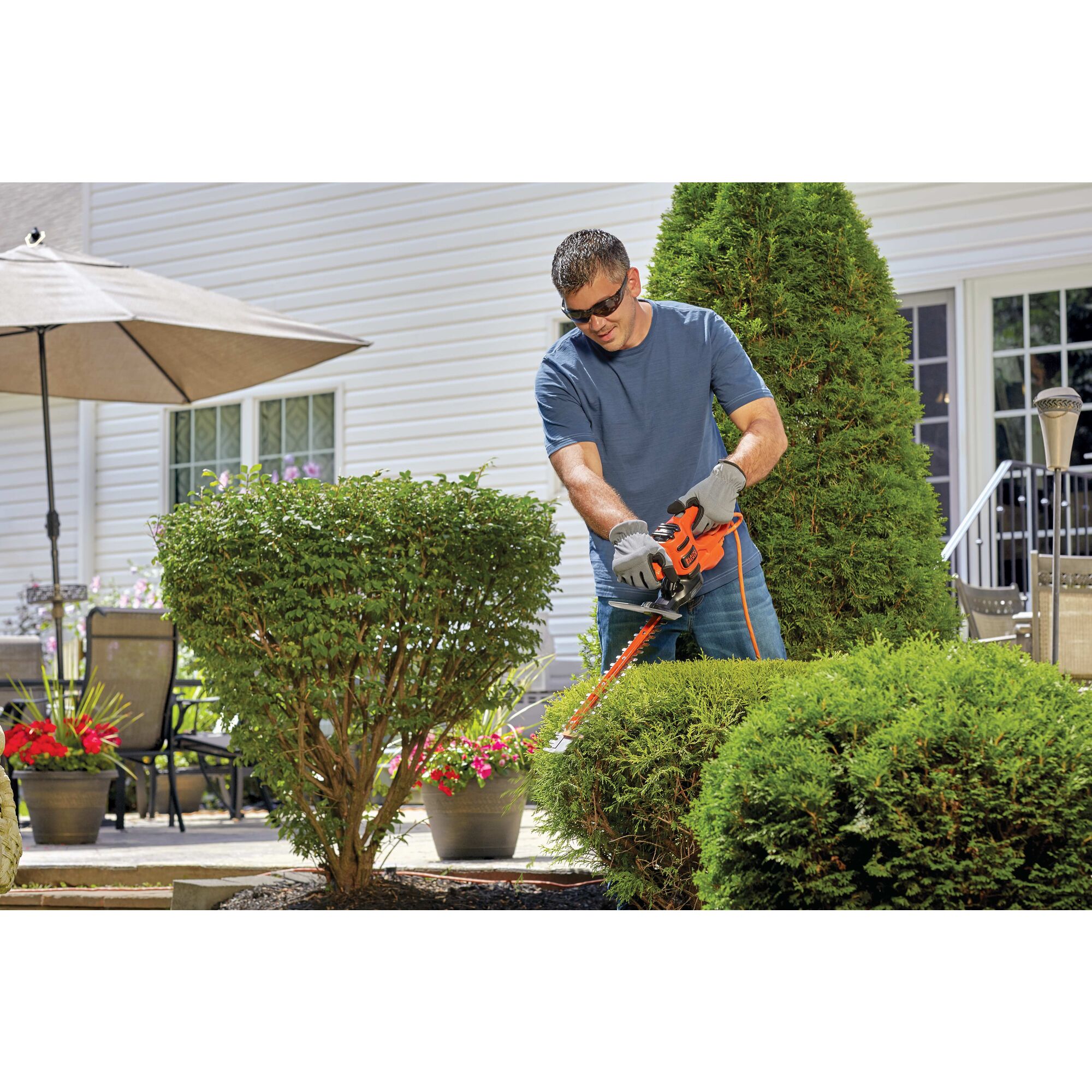 16 inch saw blade electric hedge trimmer being used by a person.