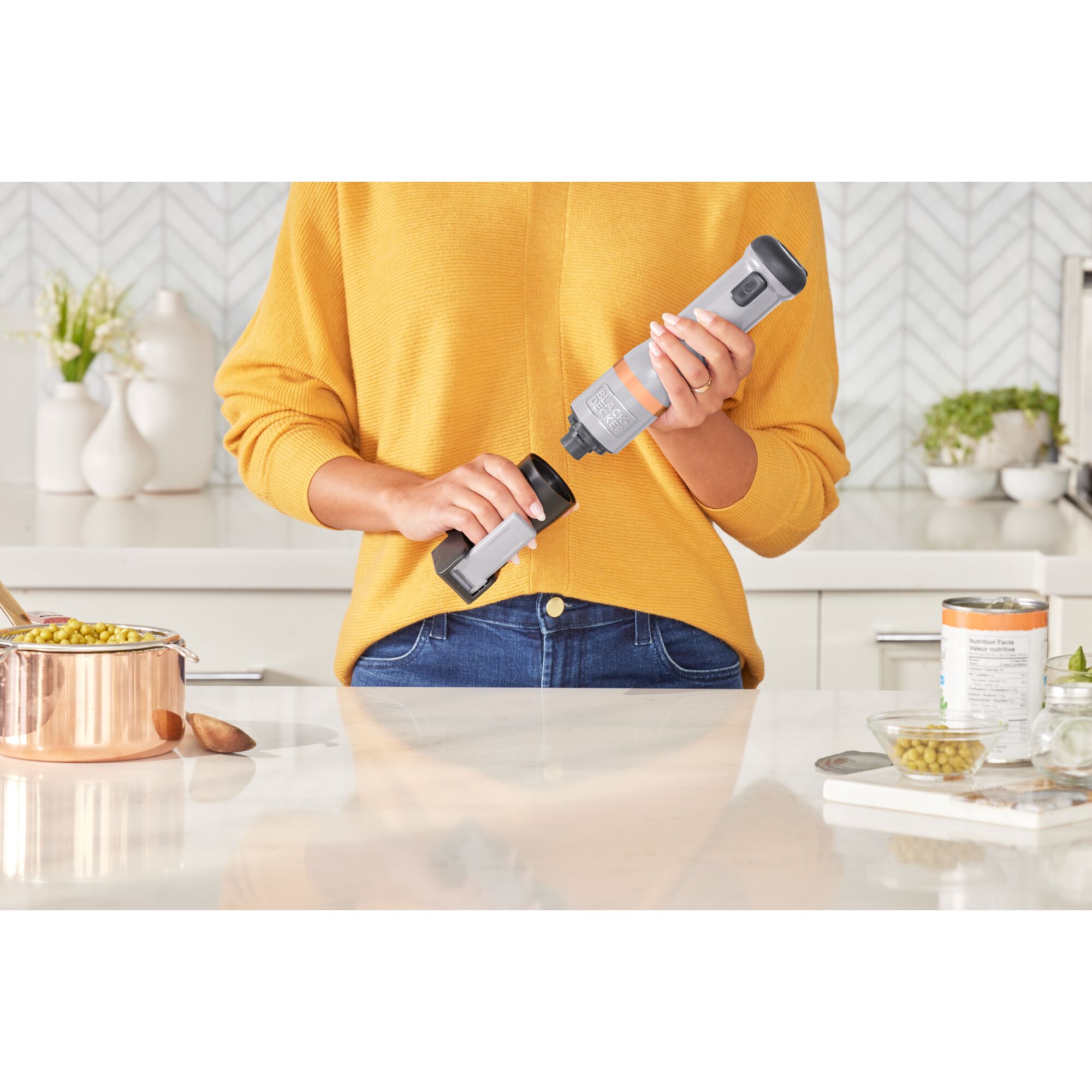 Talent showing how to attach the BLACK+DECKER kitchen wand can opener attachment to the grey power unit