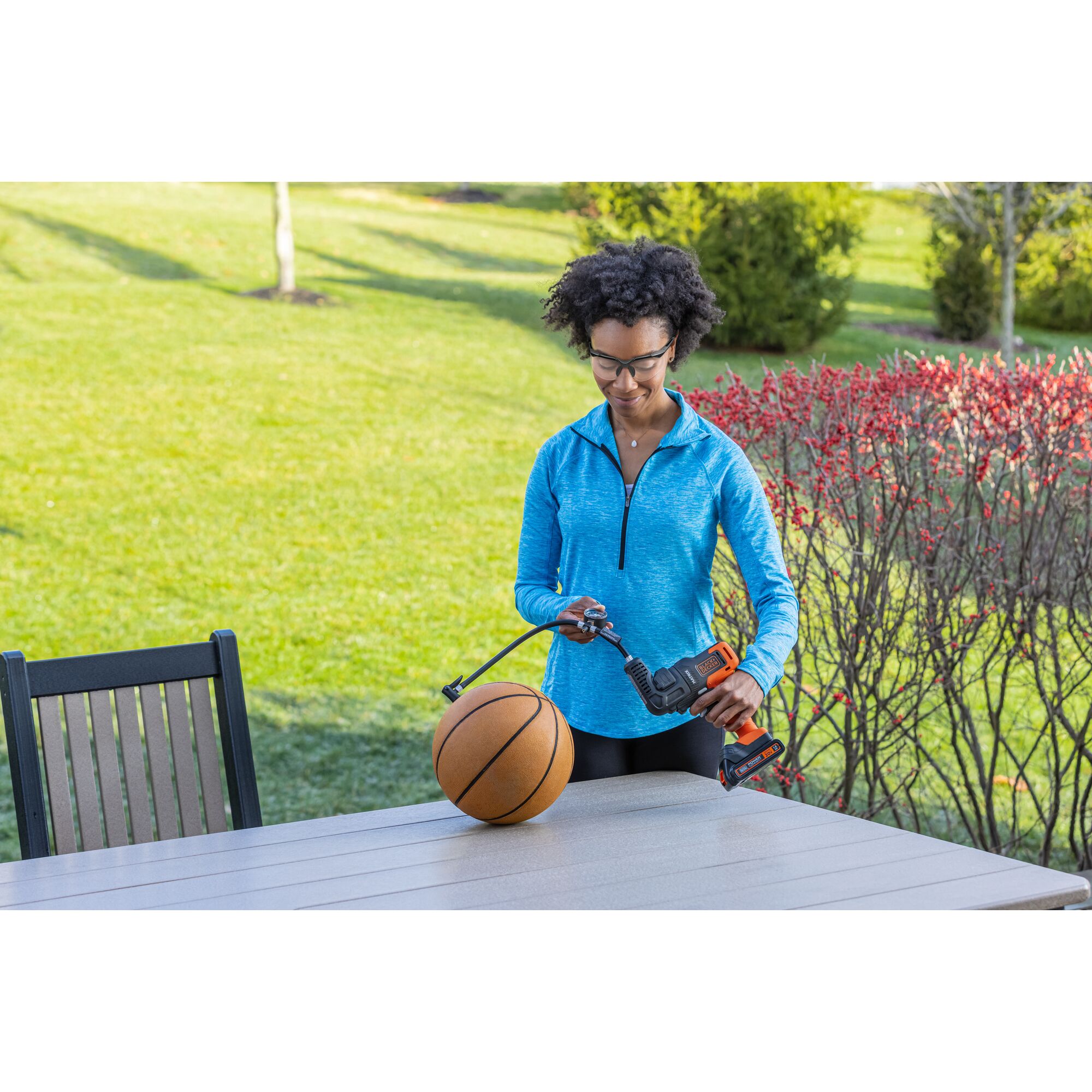 Person inflates a basketball with the BLACK+DECKER MATRIX inflator attachment