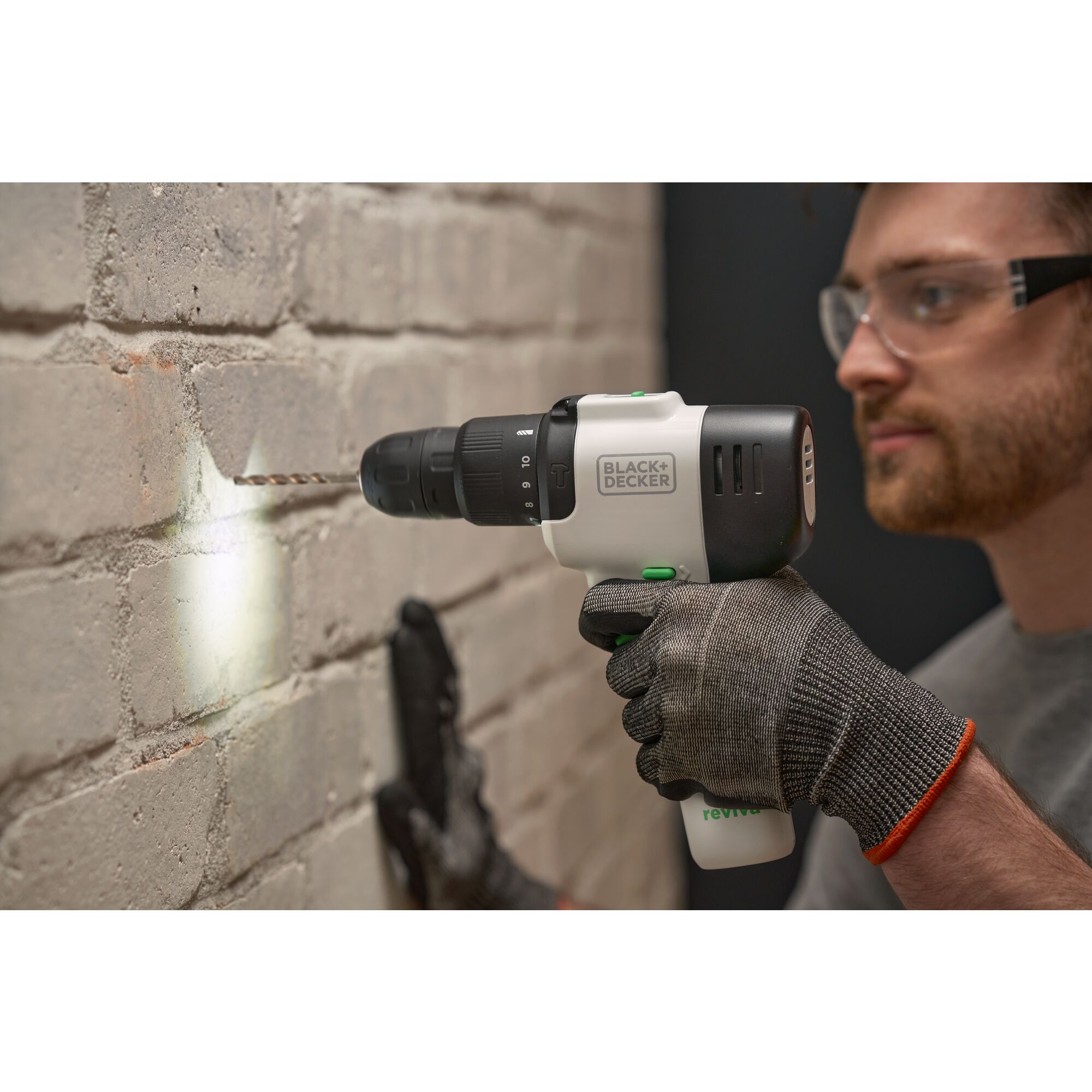 Man using reviva™ 12V MAX* Hammer Drill/Driver to drill into brick with the LED light to illuminate the workspace.