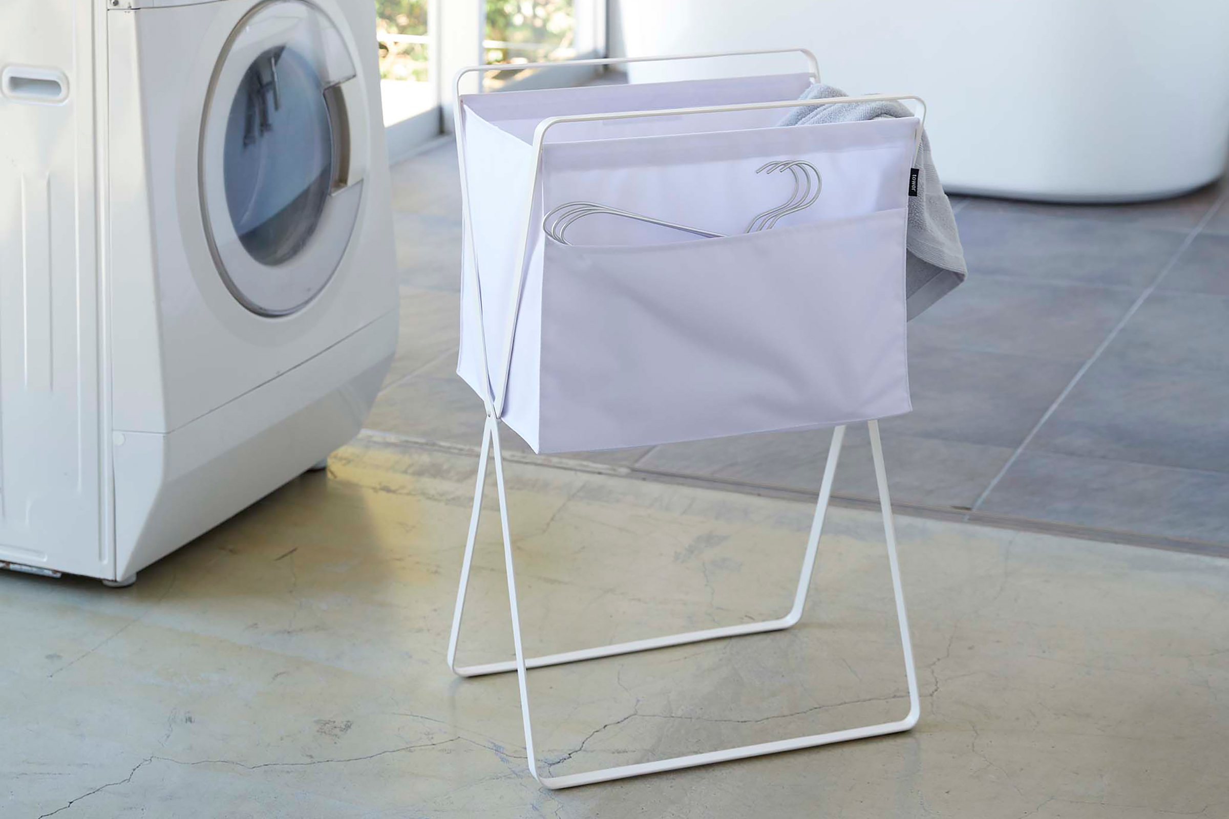White Folding Laundry Basket beside a washing machine