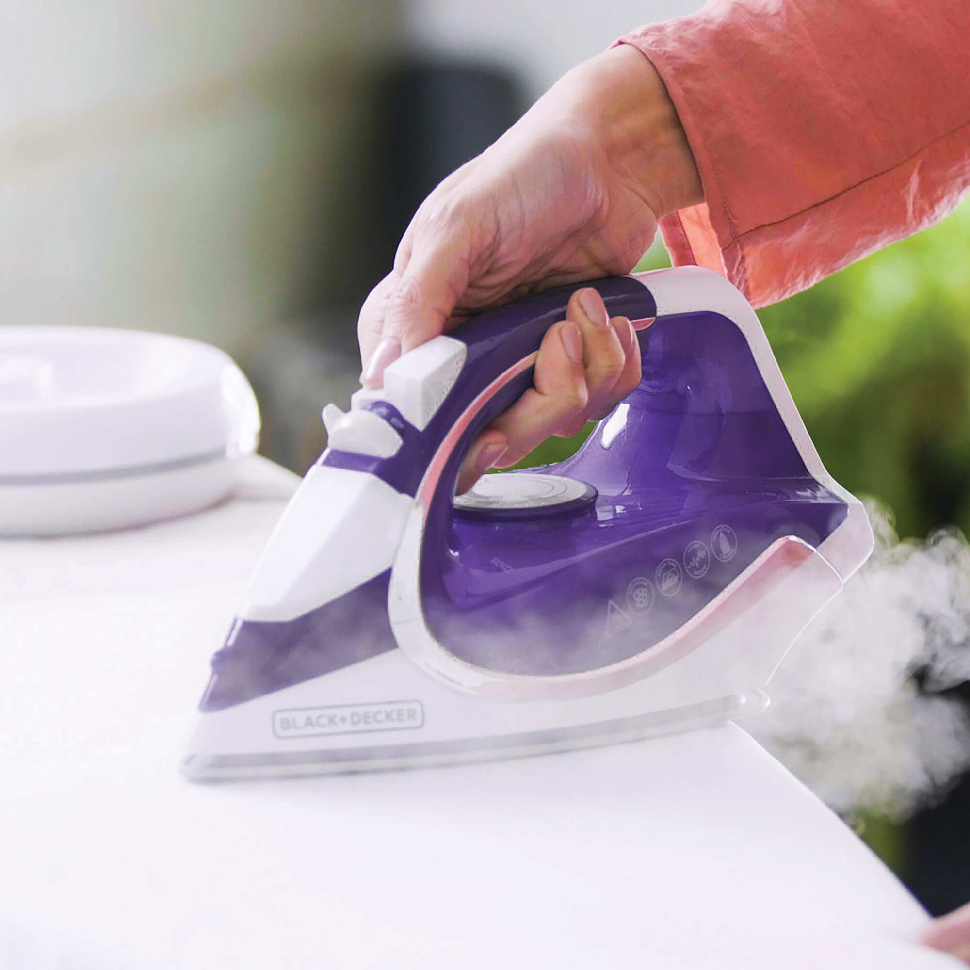 Light n go cordless iron being used to iron clothes.