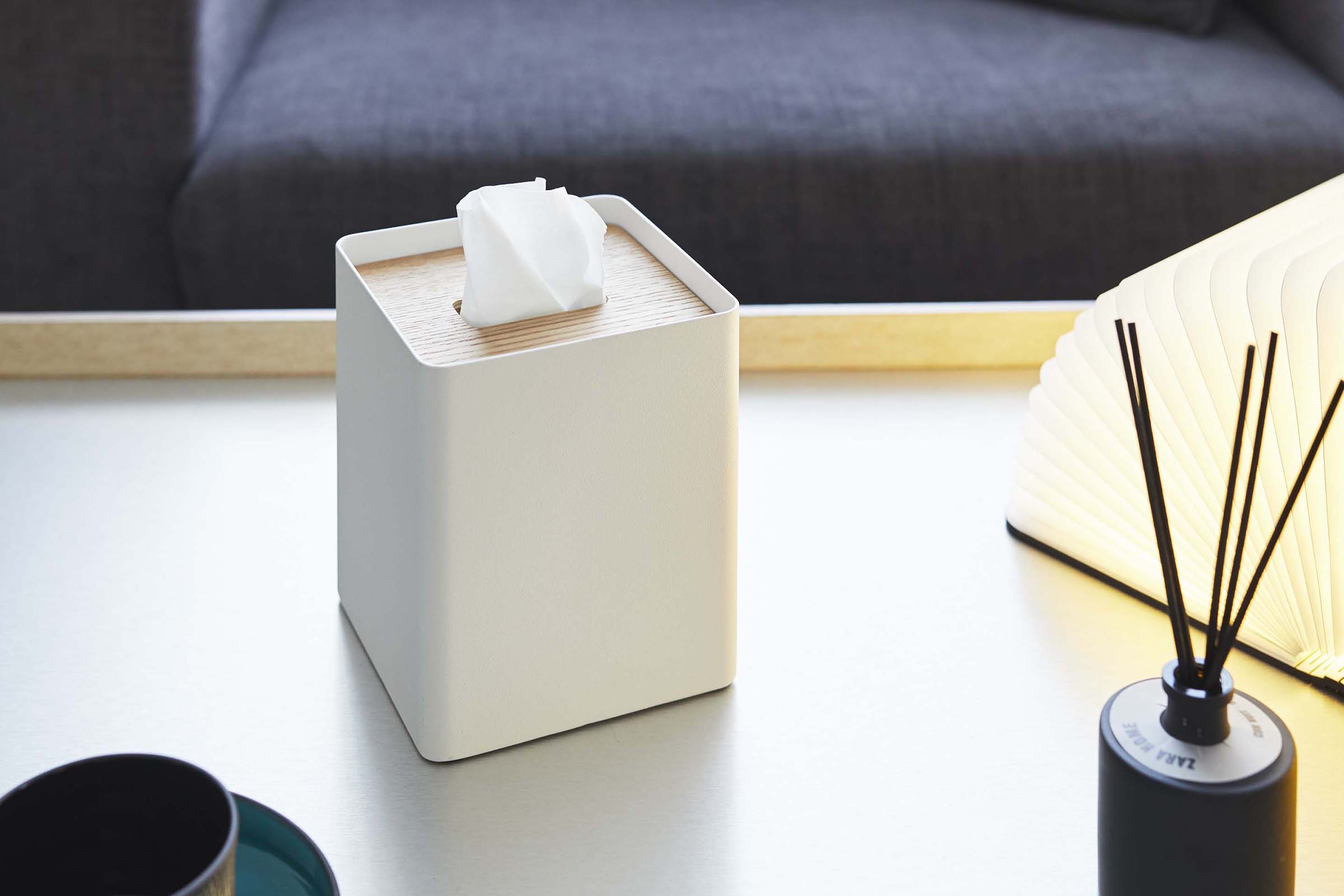 White Square Tissue Case holding tissues on coffee table by Yamazaki Home.