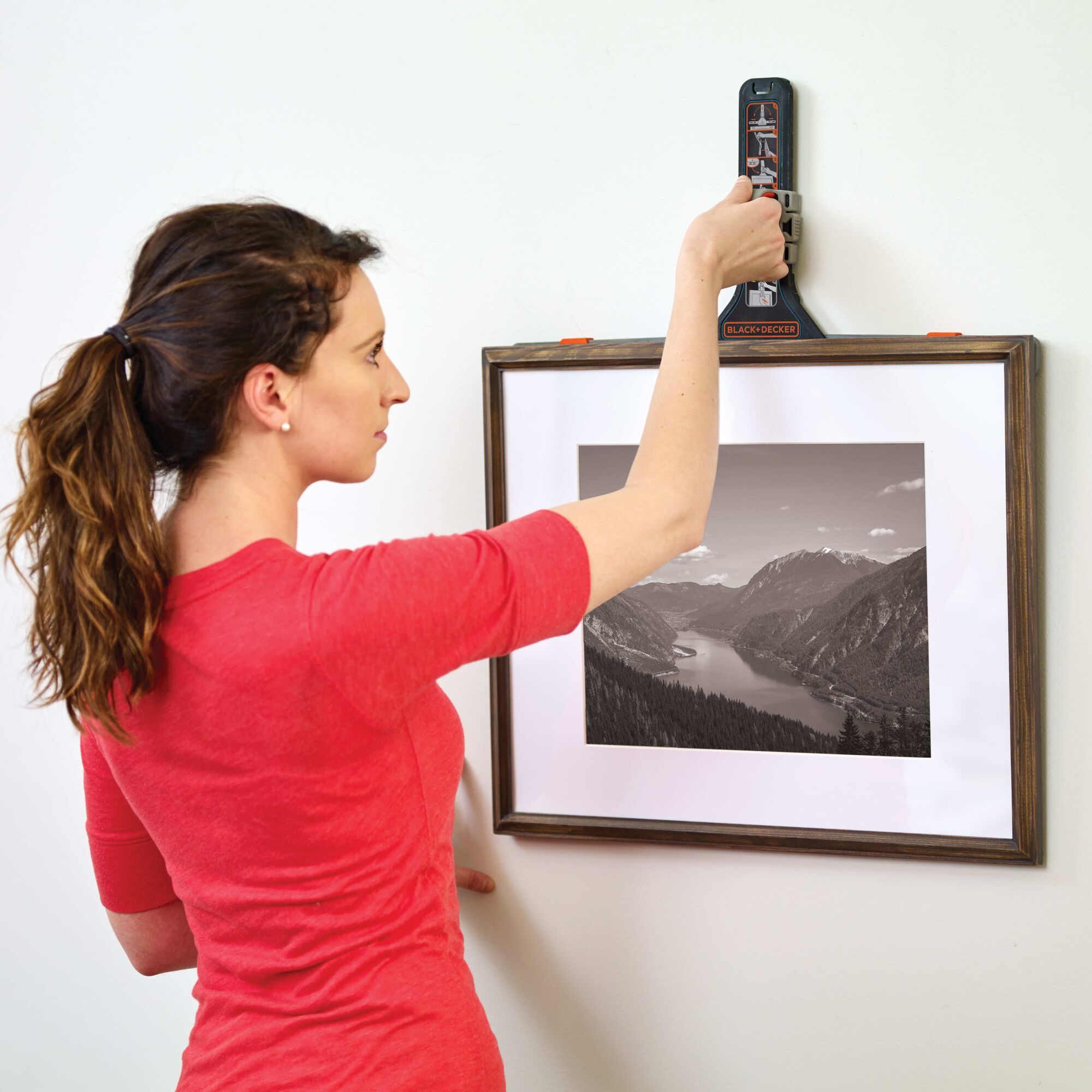 MarkIT picture hanging tool being used by a person to hang a frame.