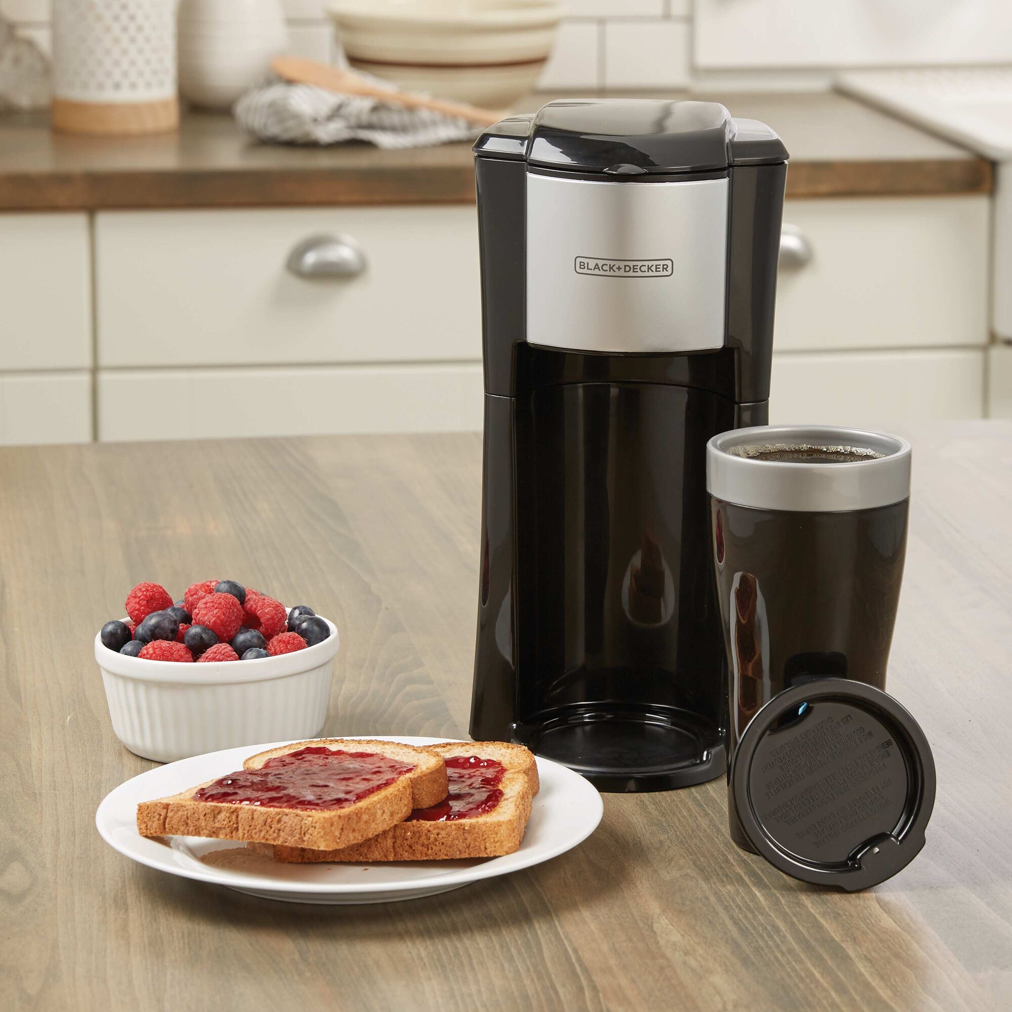 BLACK+DECKER Single Serve Coffee Maker on a kitchen table next to toast and berries