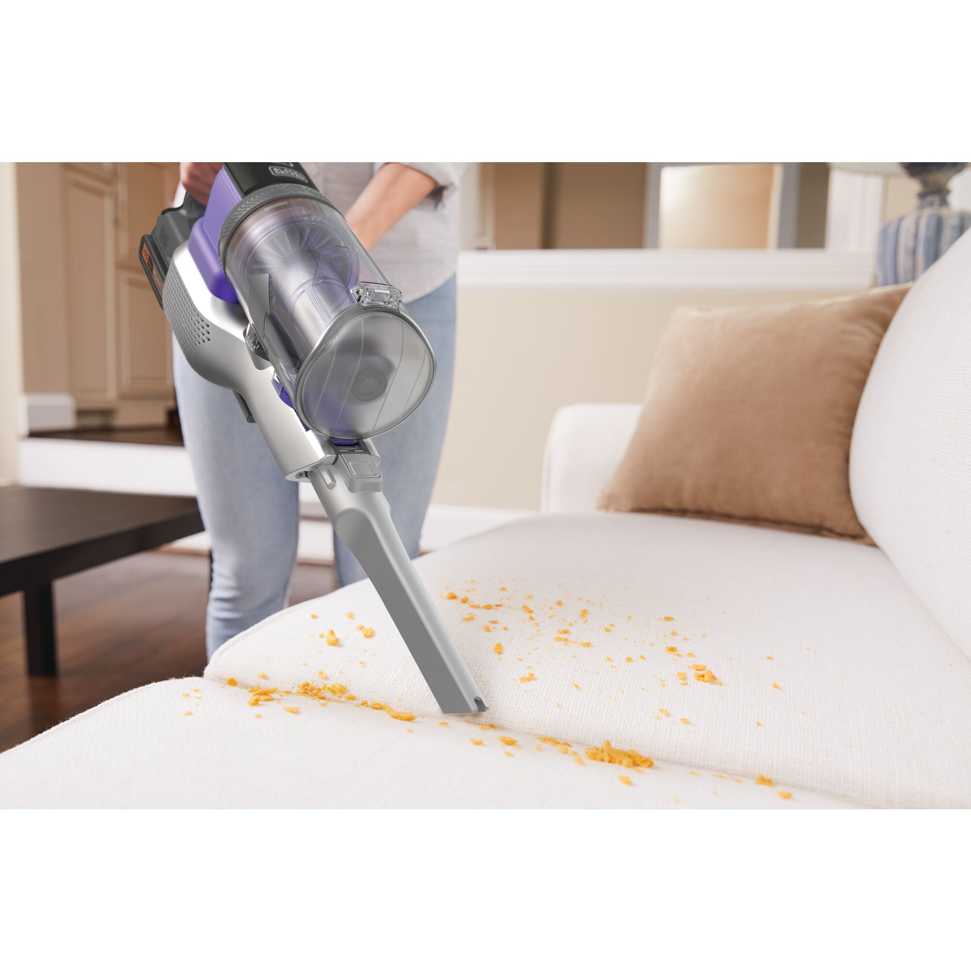 power series extreme pet cordless stick vacuum cleaner being used clean spilled material from a couch.