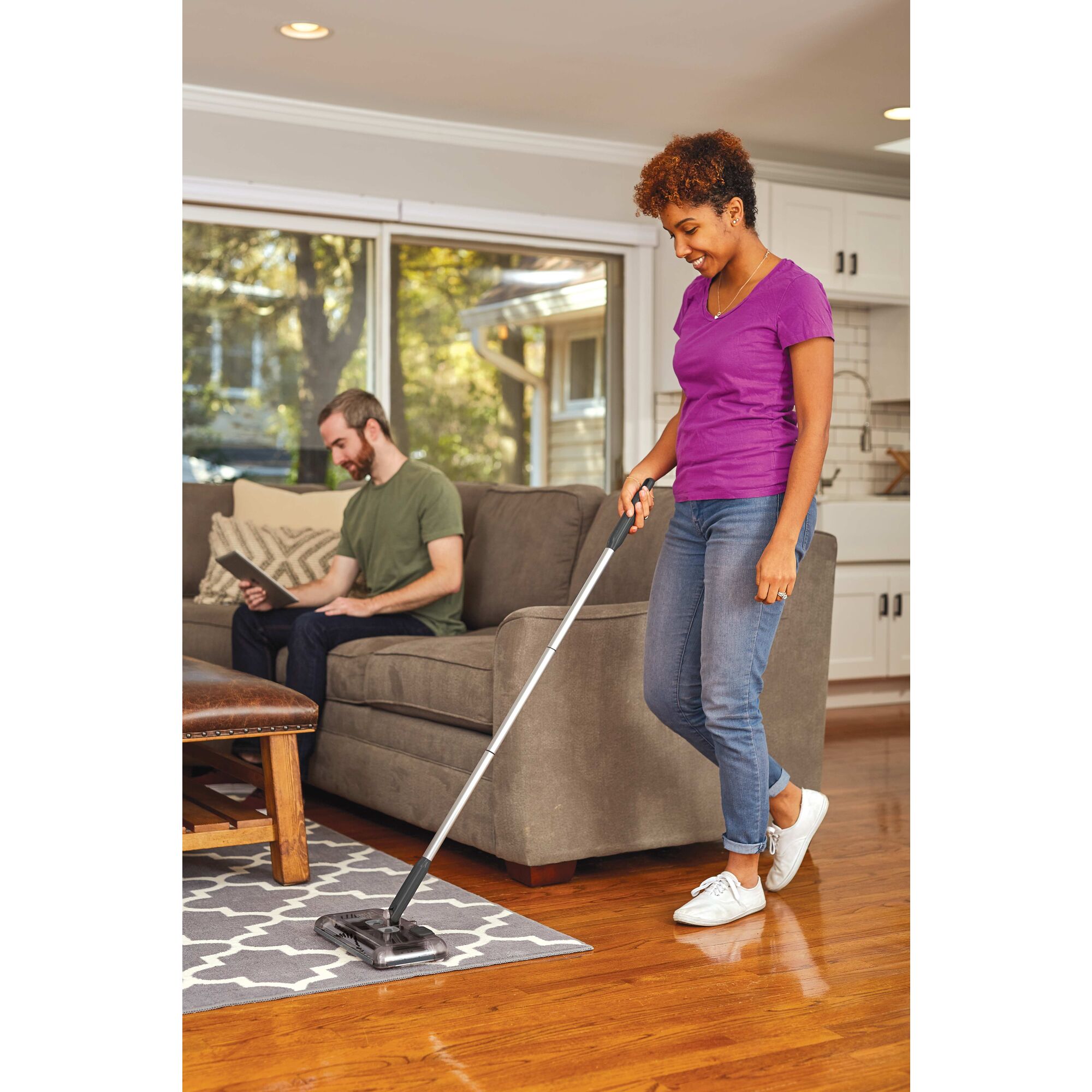 100 Minute Powered Floor Sweeper being used by person on a carpet.