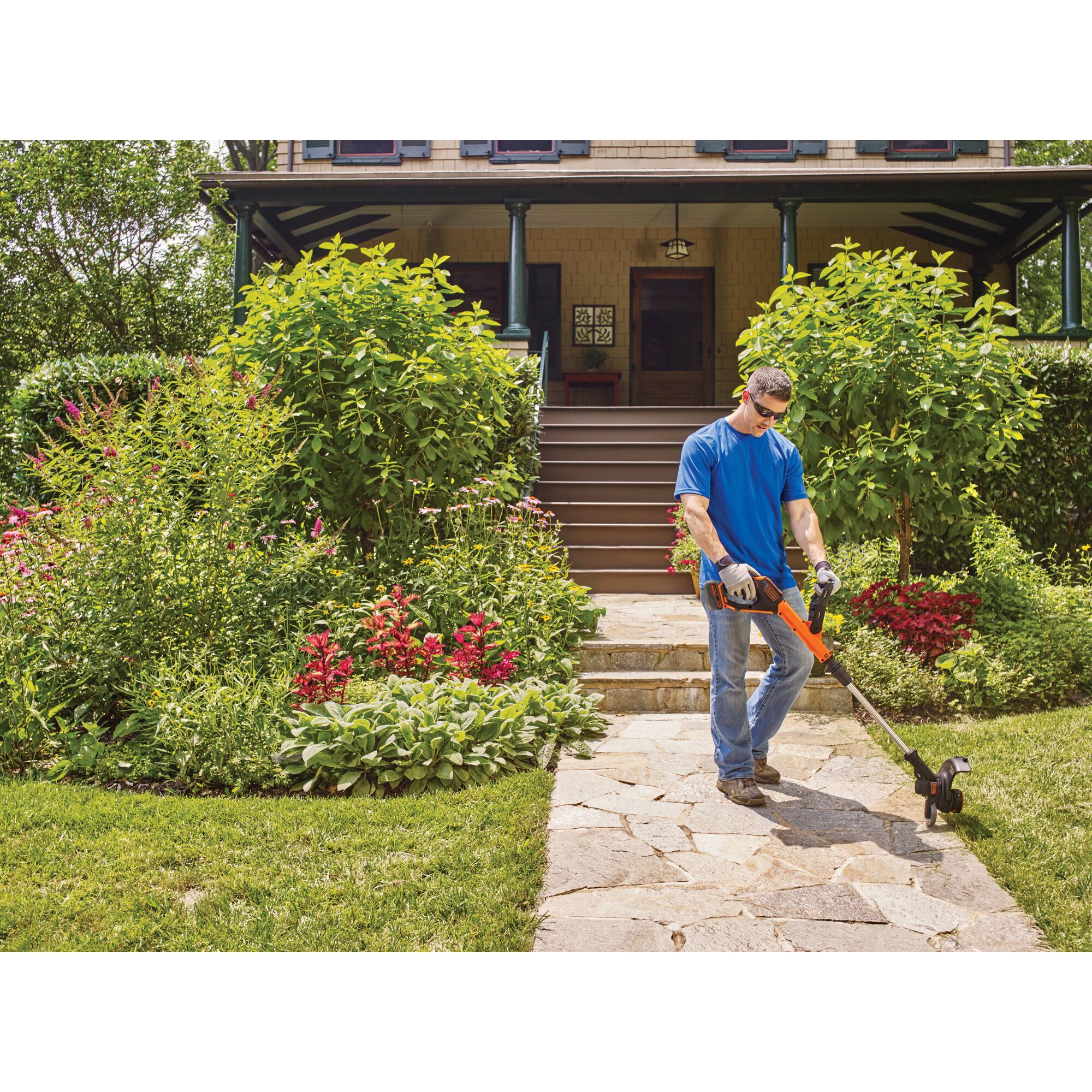 Man using 20V Max Lithium Easyfeed string Trimmer/Edger along walkway to the front door of a house.