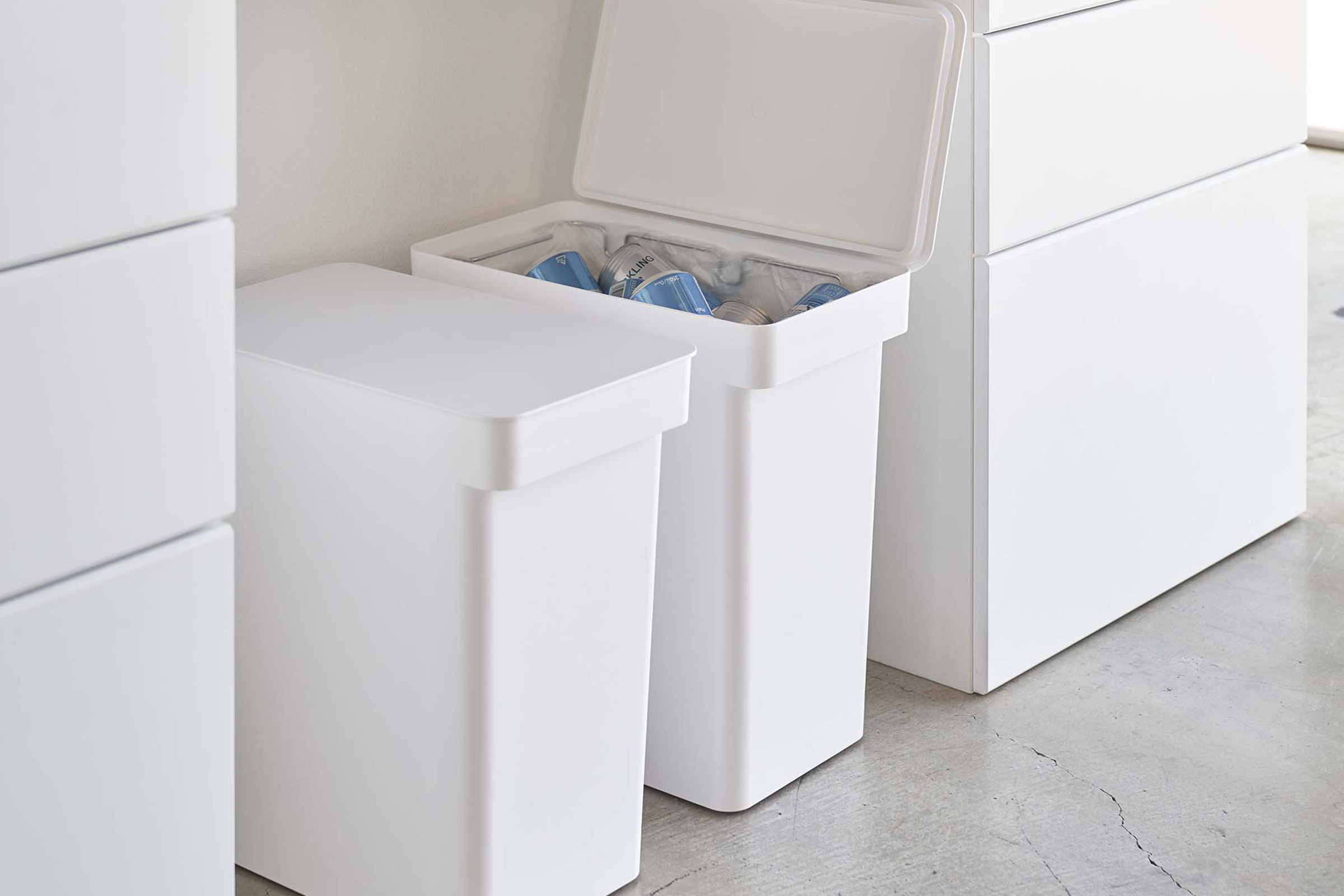 Opened and closed White Rolling Trash Cans in the kitchen by Yamazaki Home.