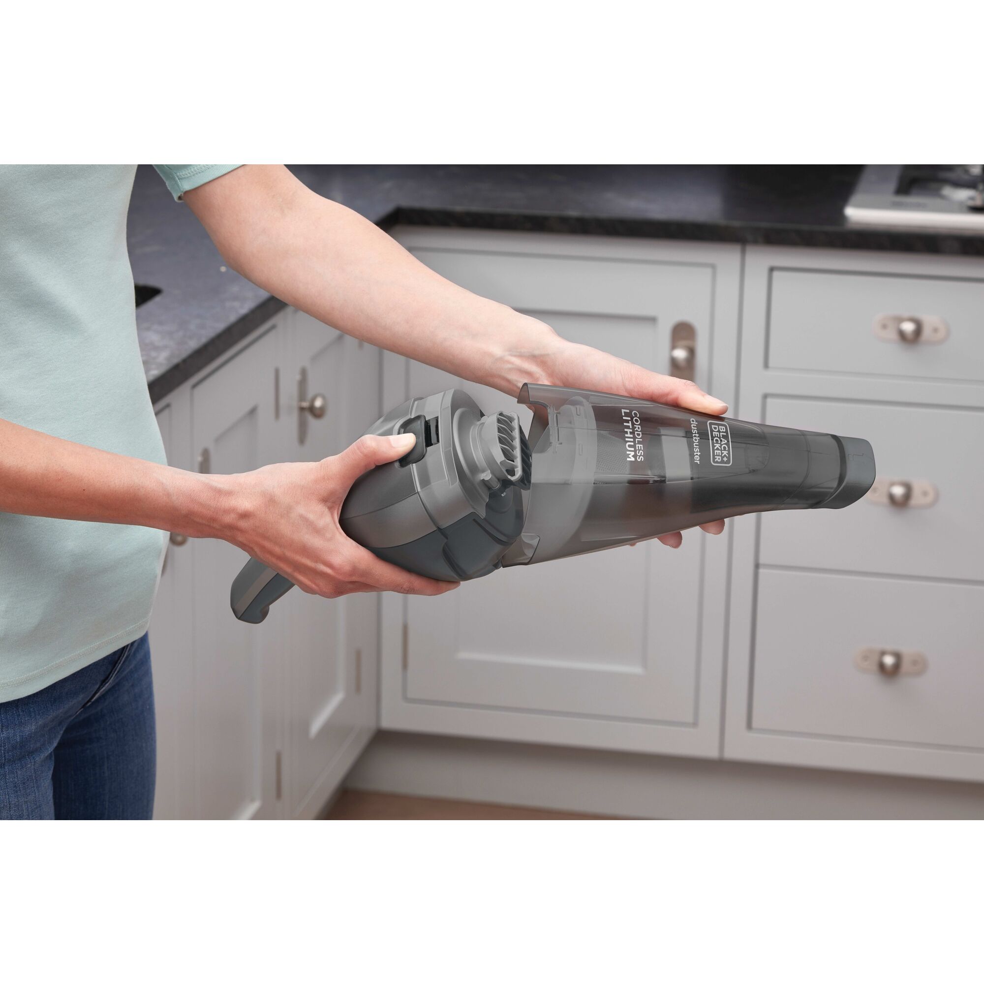 Person emptying dust bowl of BLACK+DECKER dustbuster handheld vacuum
