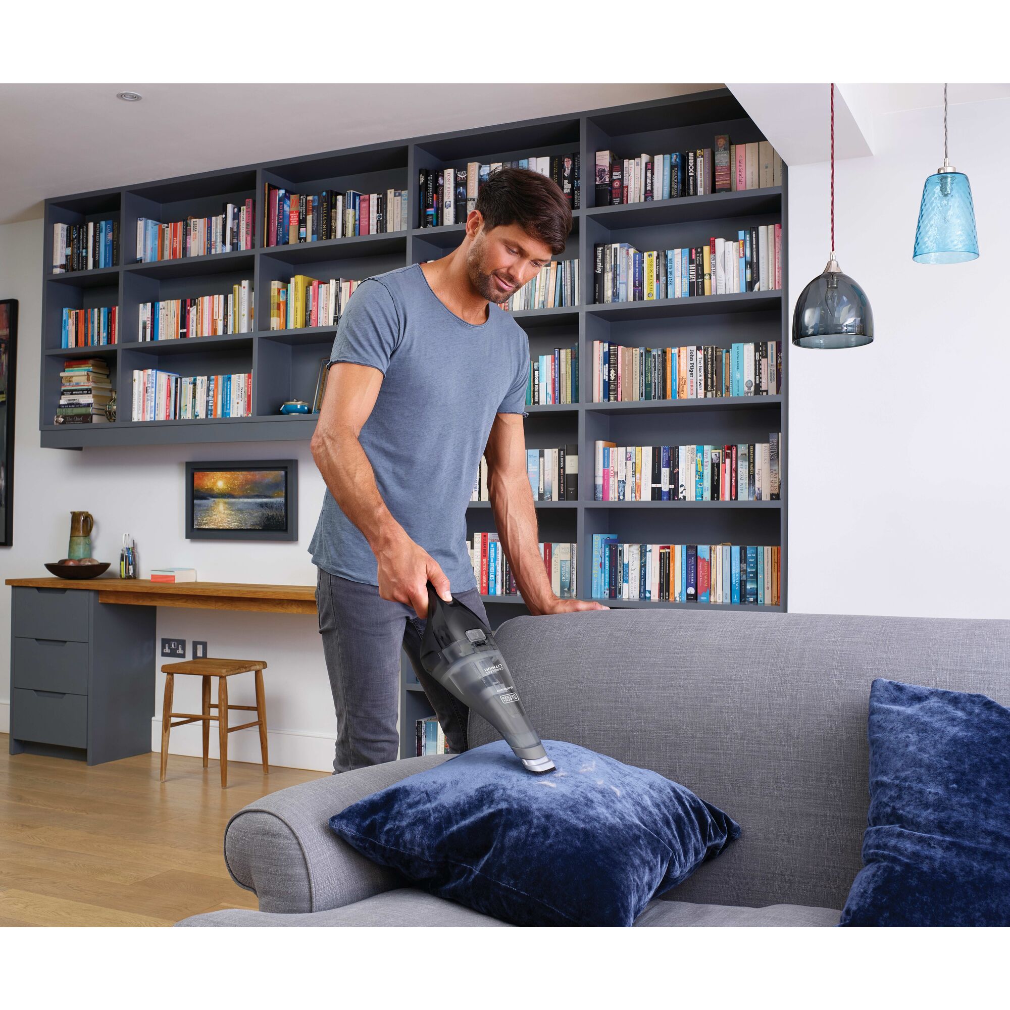dust buster Quick Clean Cordless Hand Vacuum being used by person to clean couch cushions.