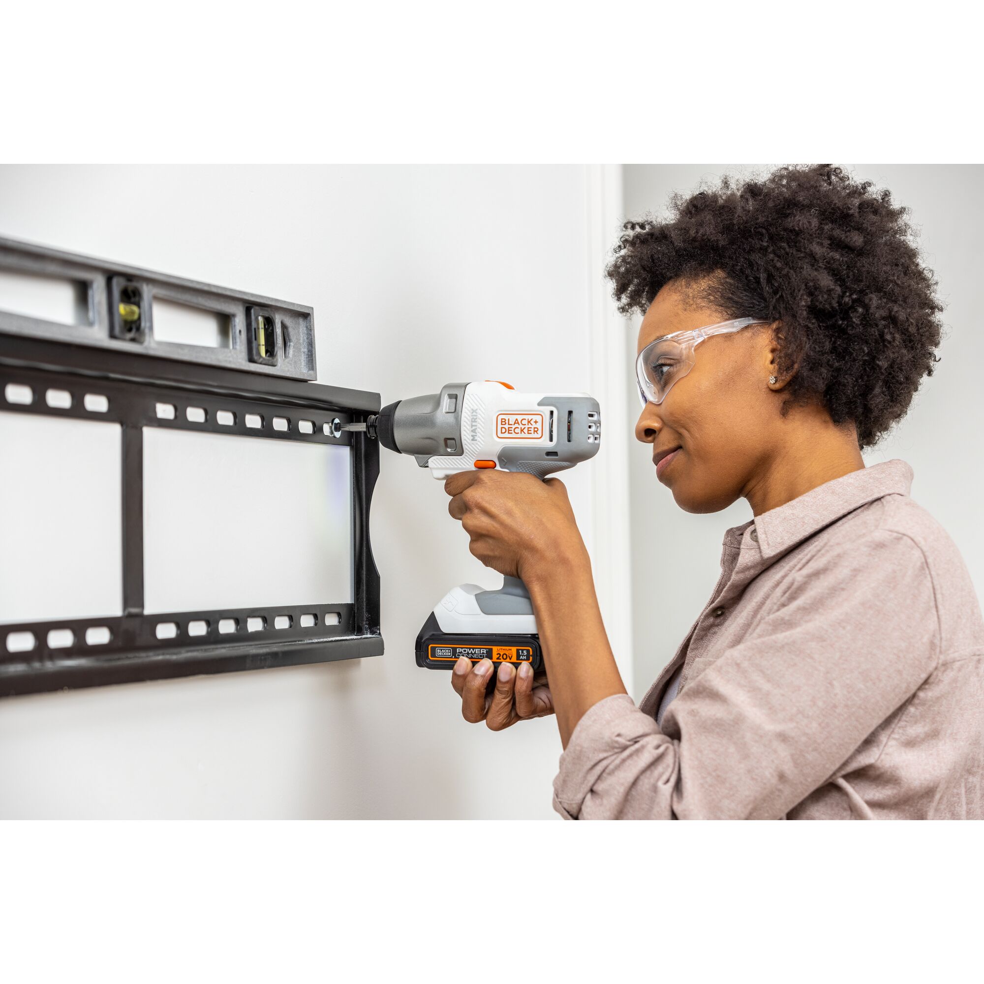 Person uses the BLACK+DECKER MATRIX impact driver attachment to fasten a lighty duty anchor in to drywall to hang a TV mount