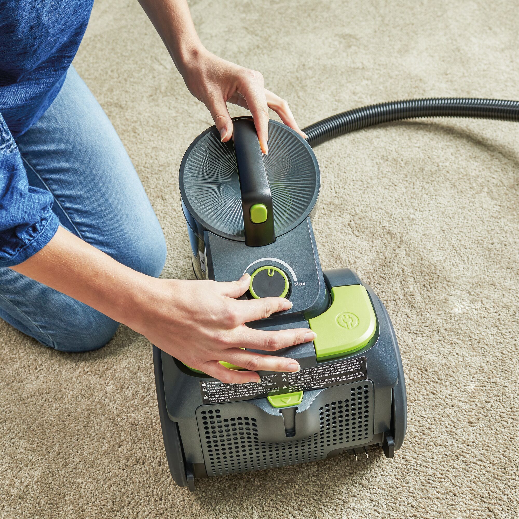 Woman turning the canister vacuum on or off.
