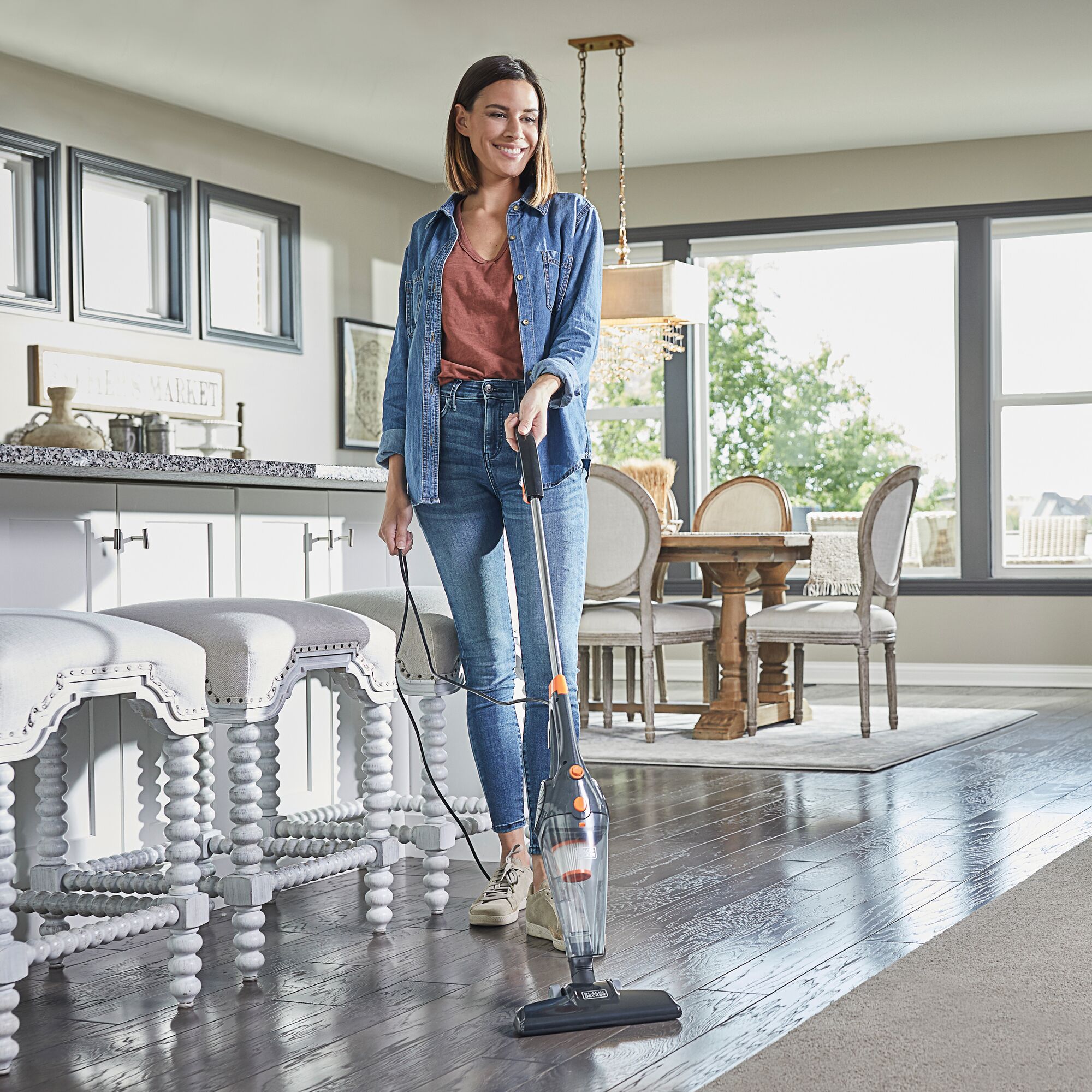 Woman using 3In1 Upright Stick Vacuum Cleaner on wood floors.