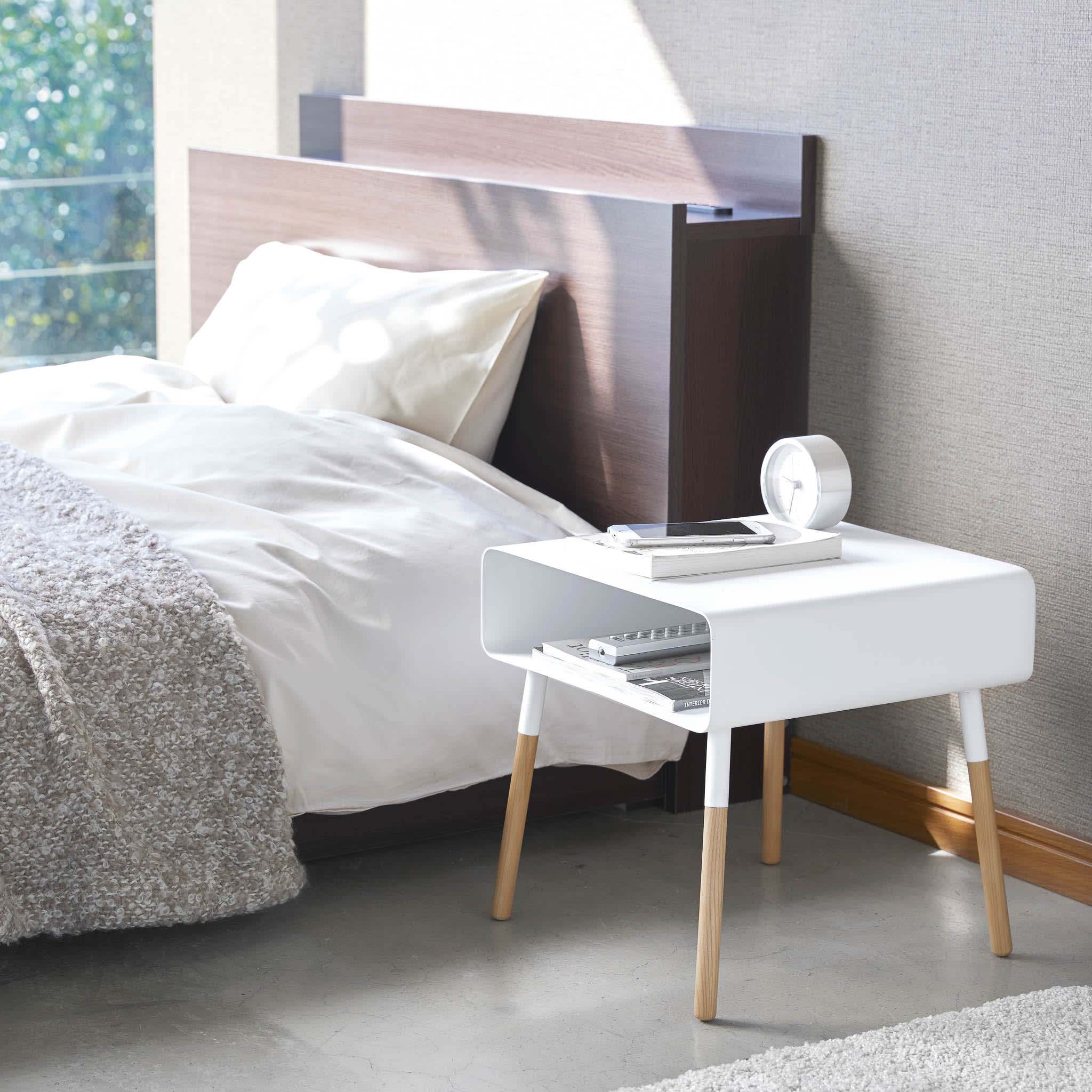 Weißer kurzer Ablagetisch für Bücher und Telefon im Wohnzimmer von Yamazaki Home.