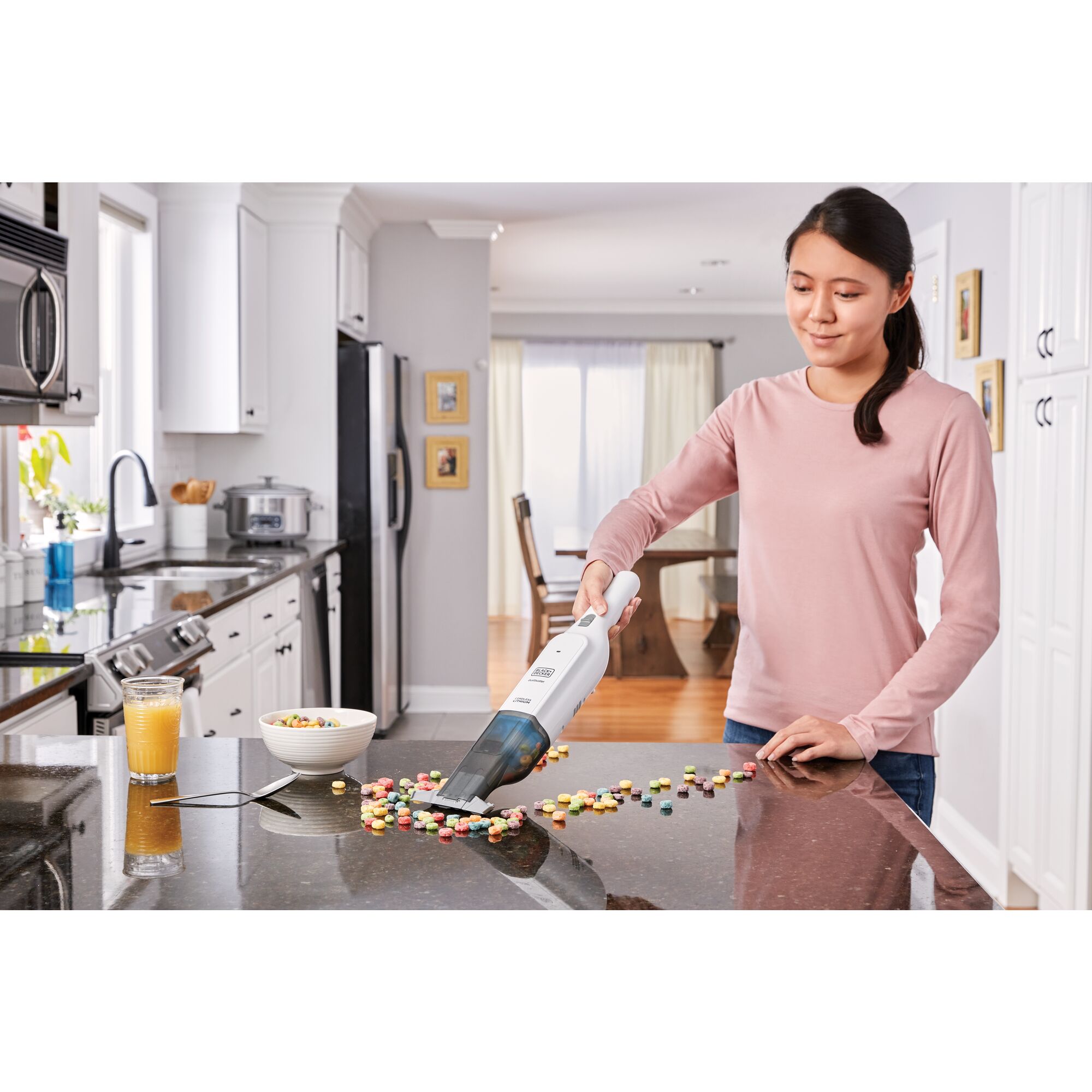 dustbuster 12 volt MAX AdvancedClean cordless hand vacuum being used by a person to clean food spillage on kitchen counter.