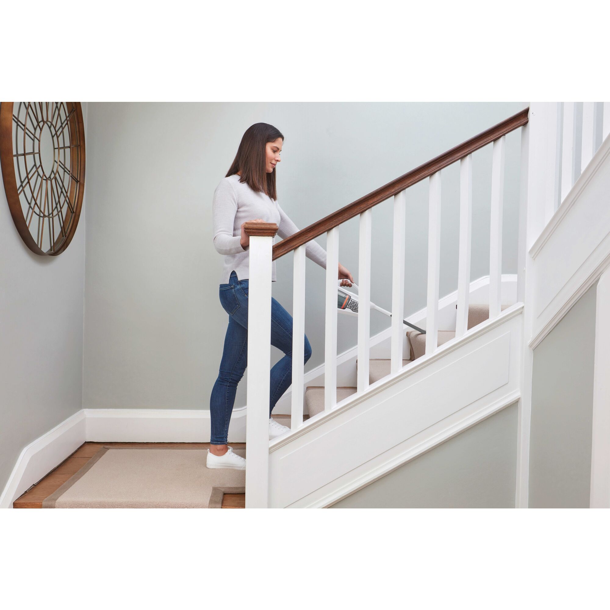 Dustbuster advanced clean plus cordless hand vacuum being used by a person to clean stairs.