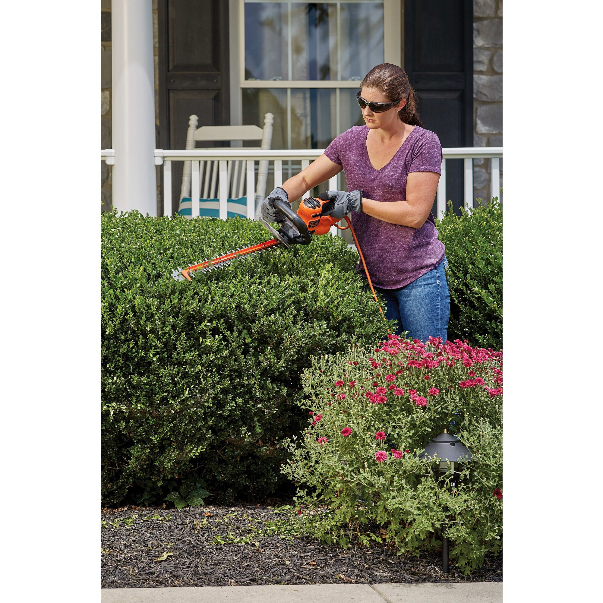 22 inch SAW BLADE Electric Hedge Trimmer being used by a person on a hedge.