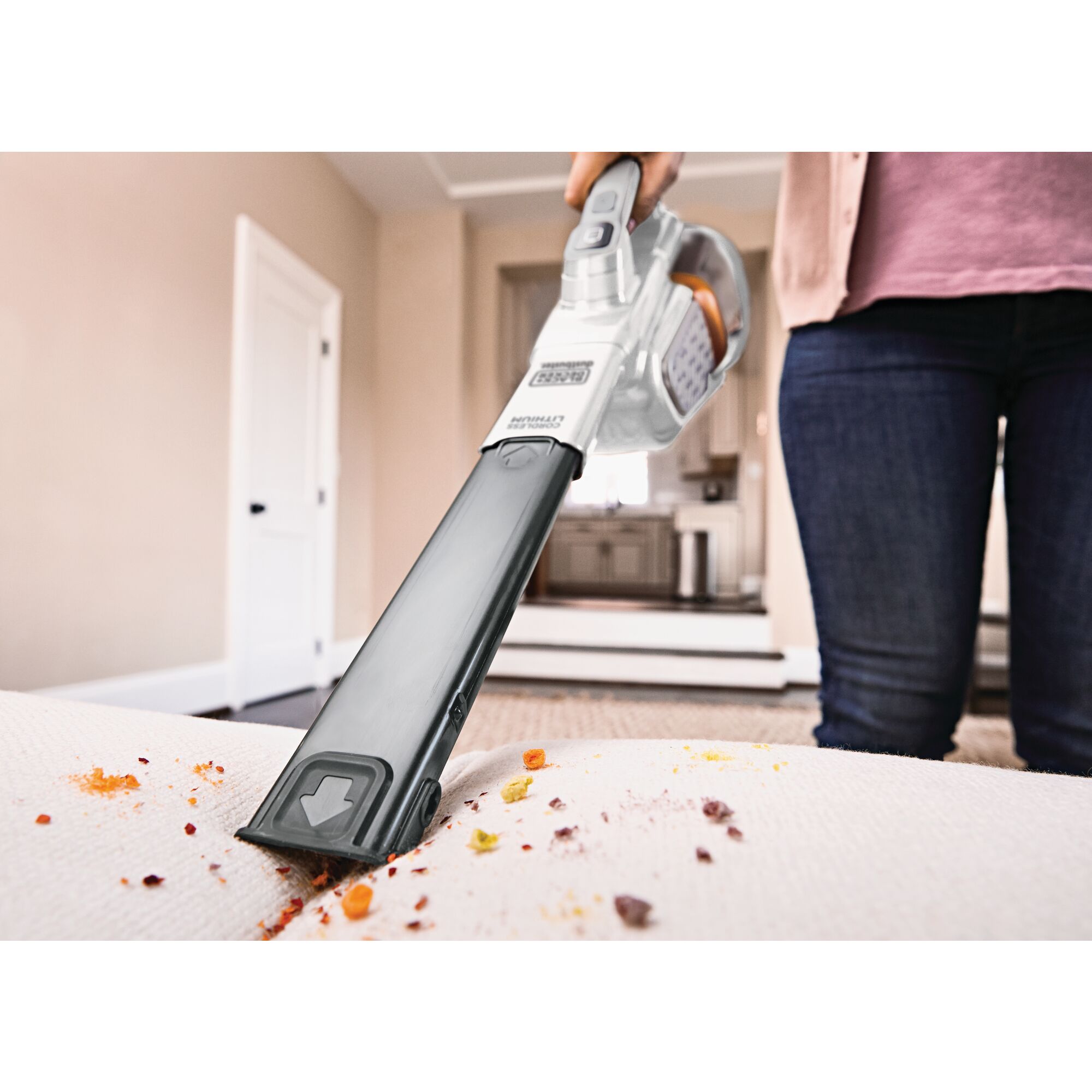 Woman cleaning sofa with BLACK+DECKER dustbuster