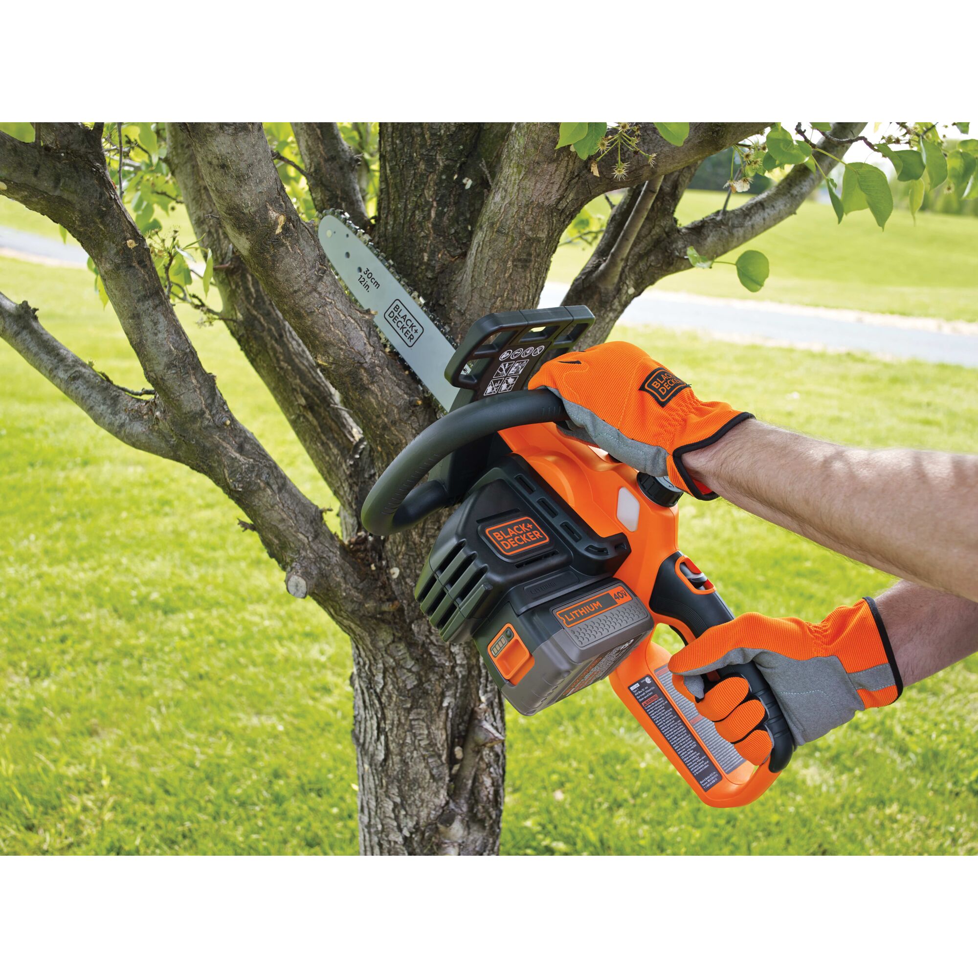 Person using chainsaw to cut tree limbs